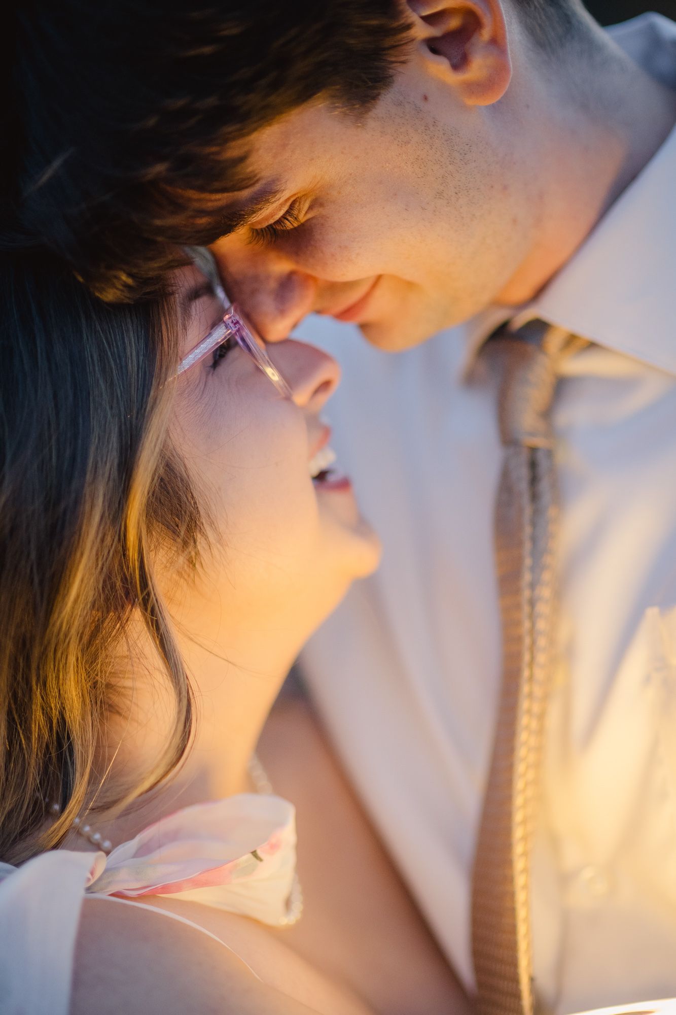 Woman in glasses gazing up at her fiance in warm golden light, engagement photo in the mountains near Chama, NM.