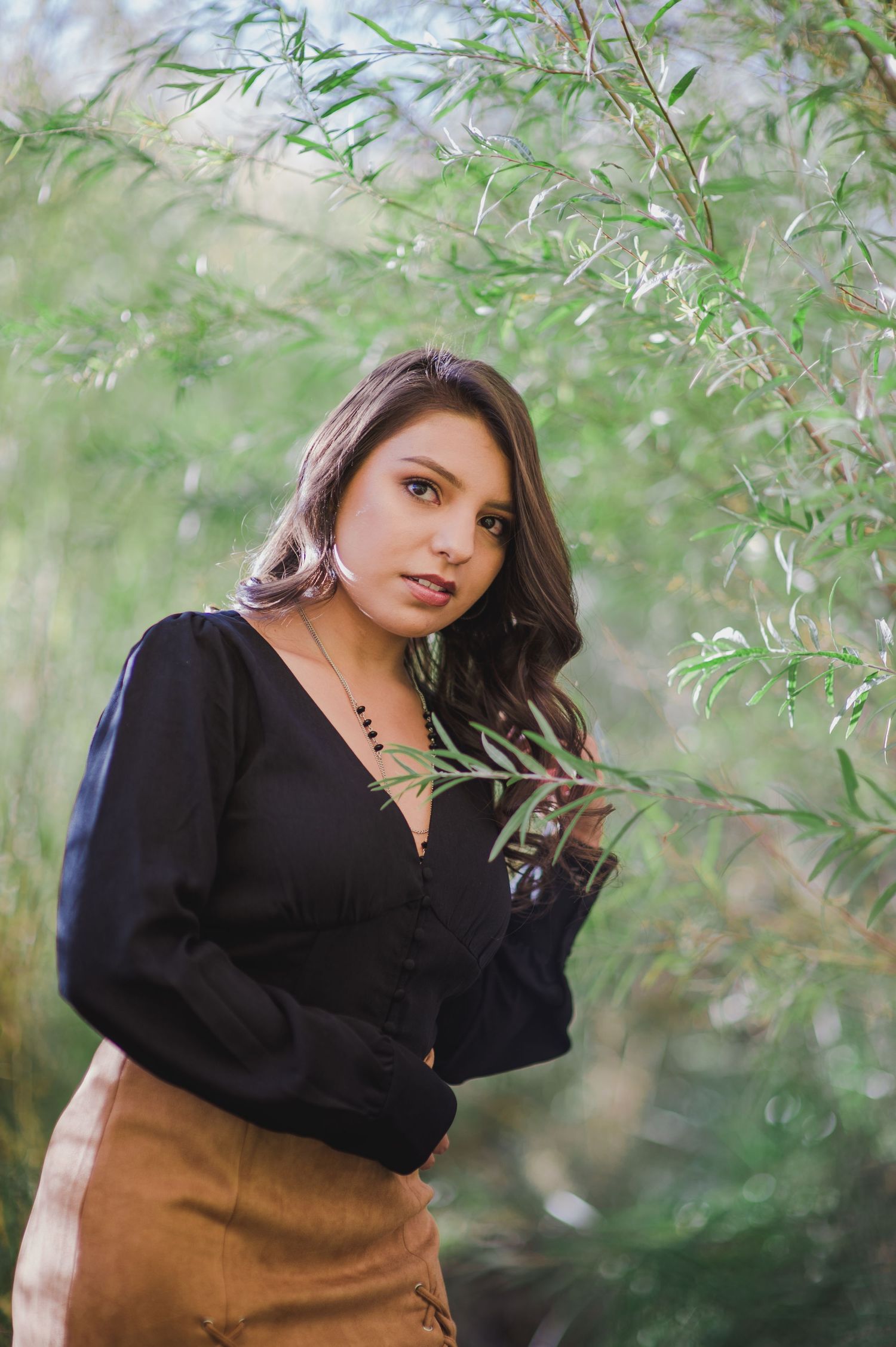 Fashion portrait with delicate willow branches and natural lighting.