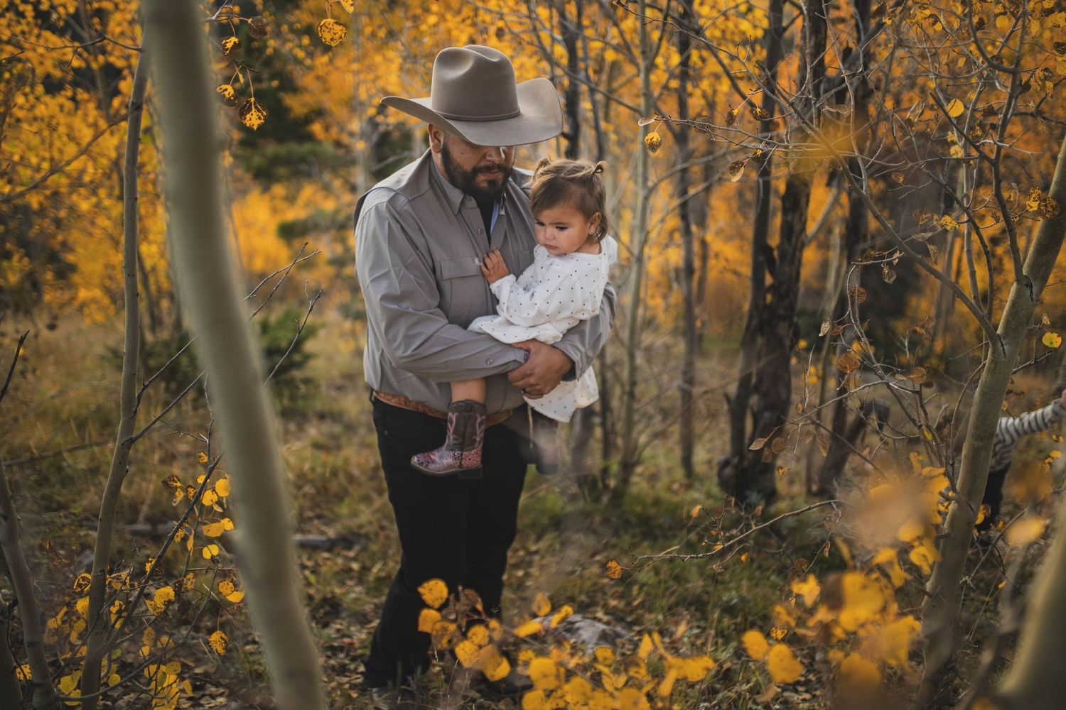 Tender moment of dad carrying toddler daughter in golden autumn light — natural storytelling by Quiet Light by The Amoras.