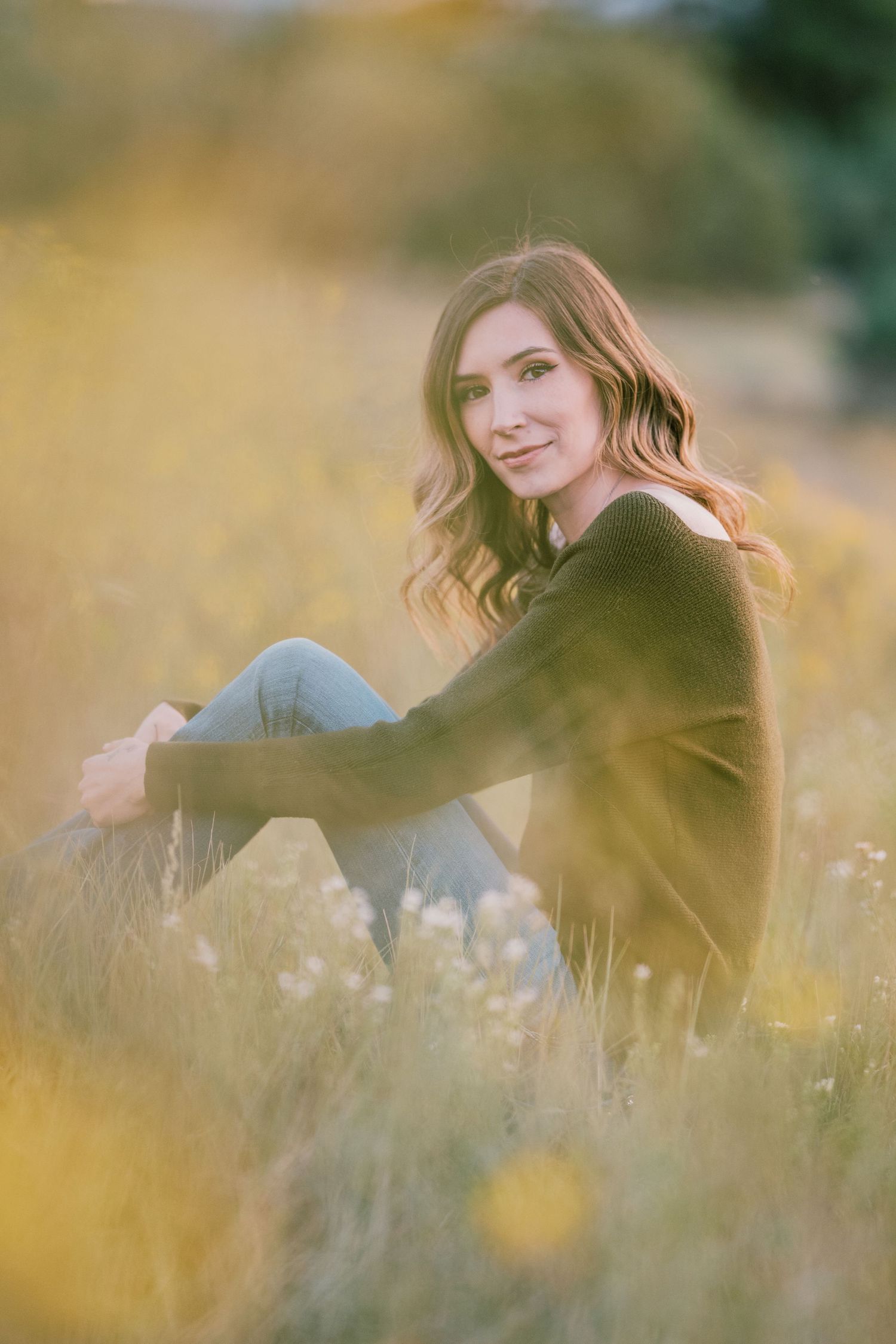 Woman relaxing in a golden meadow with soft natural lighting.