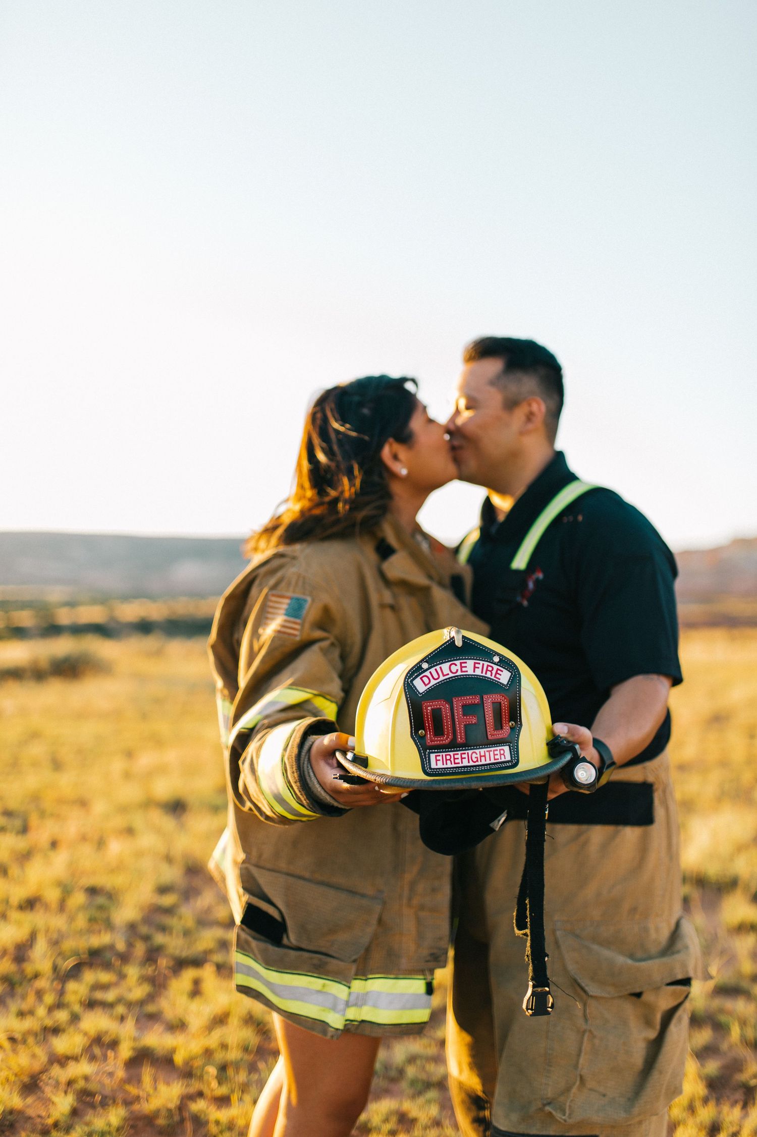 A firefighter couple shares affectionate moments during their engagement photoshoot.
