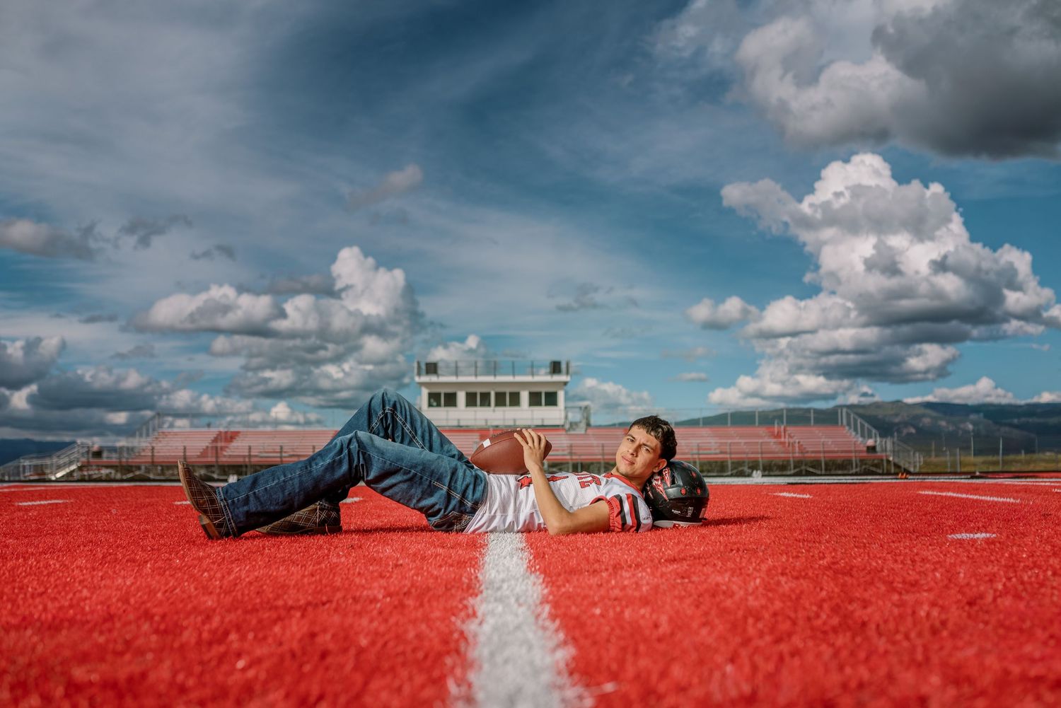 A panoramic sequence of someone lying in a vibrant red flower field under dramatic cloudy skies.