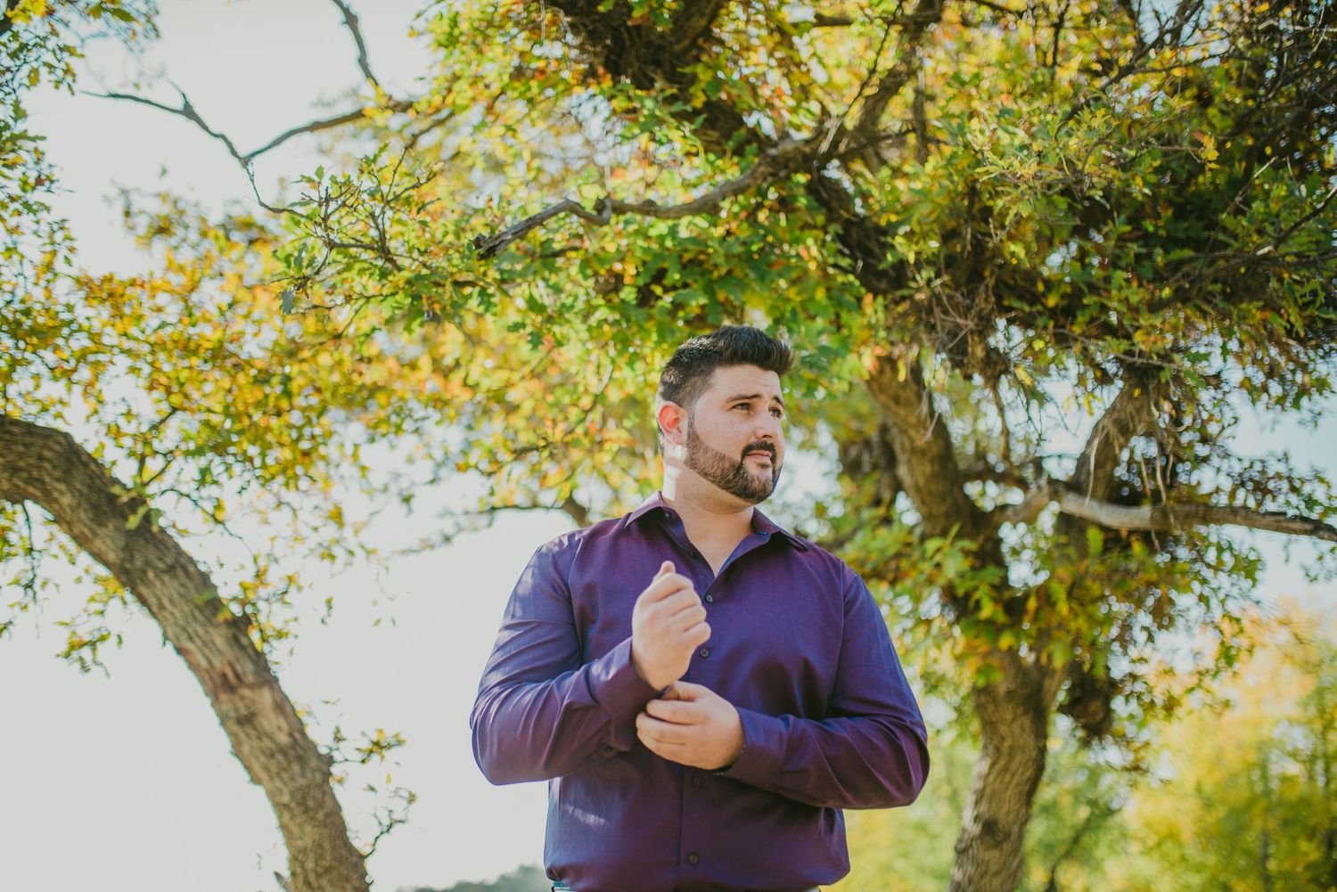 Fall wedding portraits showing couple in candid moments under yellow-leaved trees.
