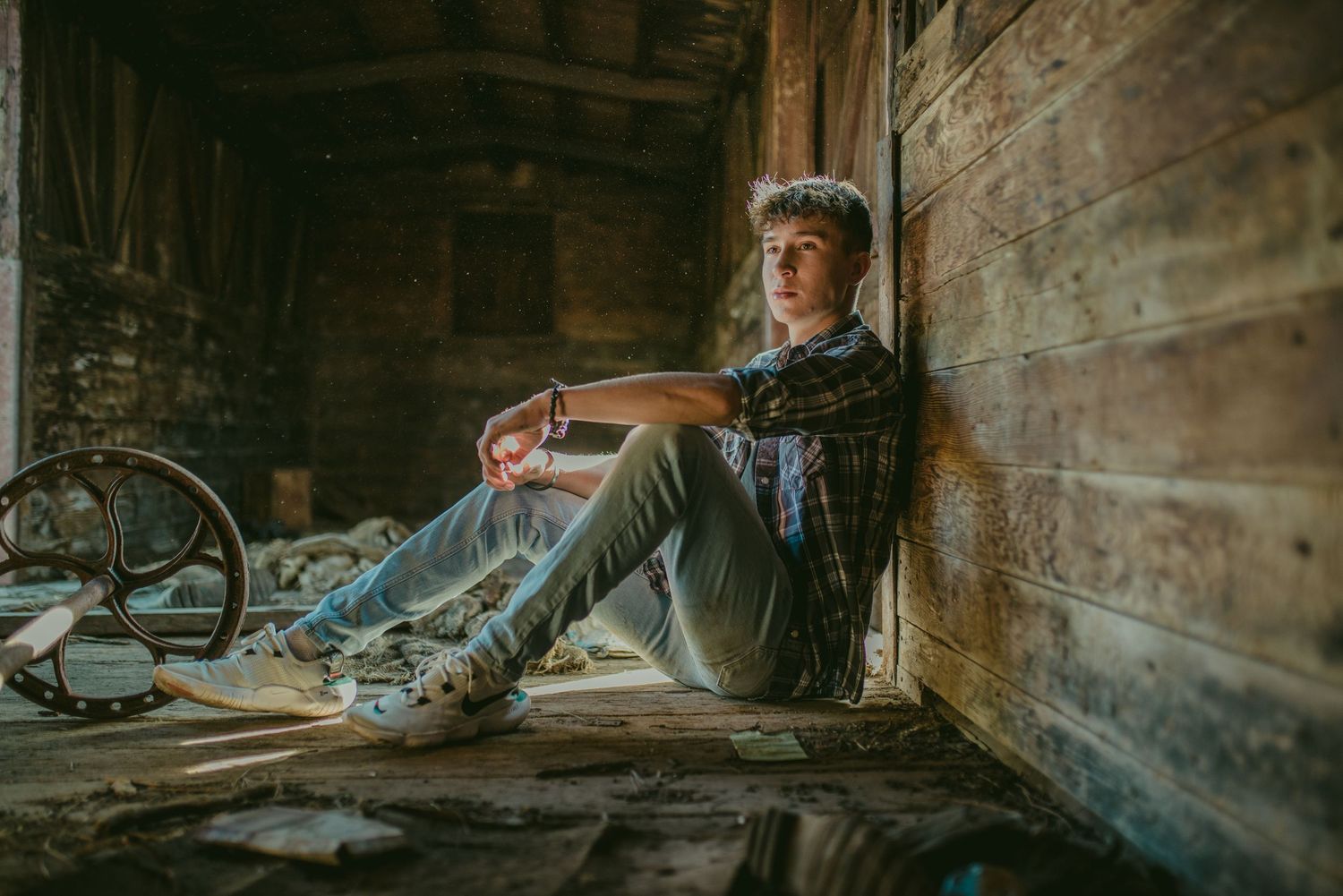 Moody portrait in rustic wooden barn interior with vintage ambiance.