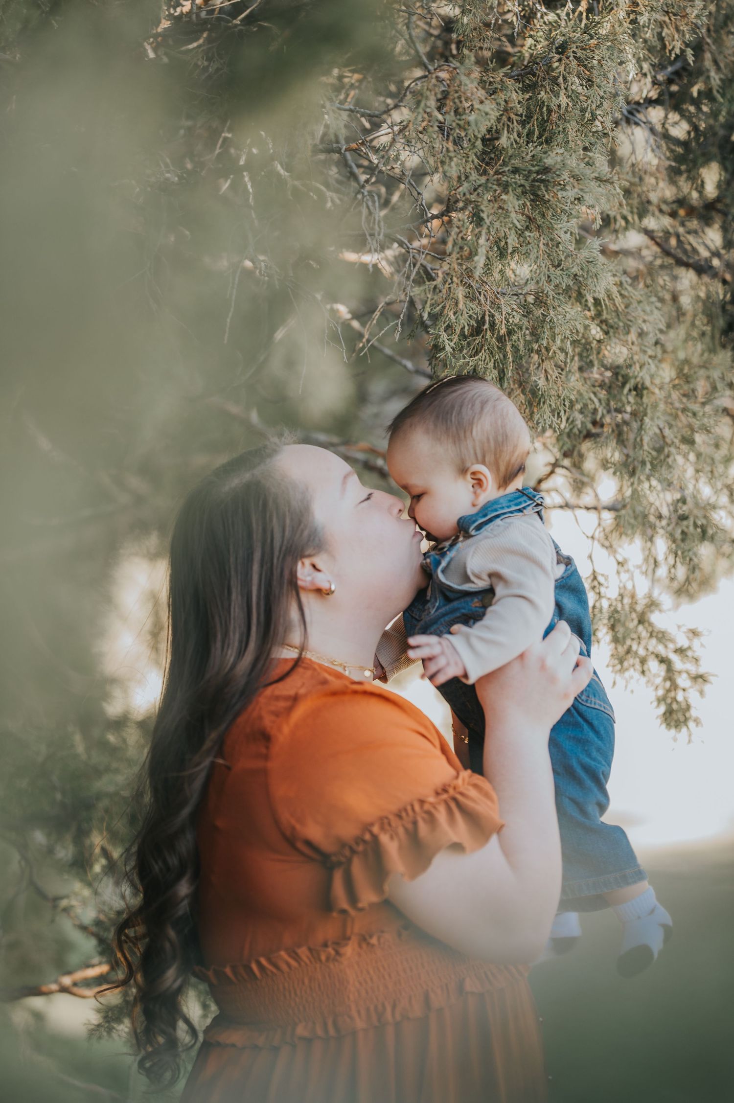Mother and young child sharing a quiet moment among the pines — serene family photo by The Amoras in northern New Mexico.
