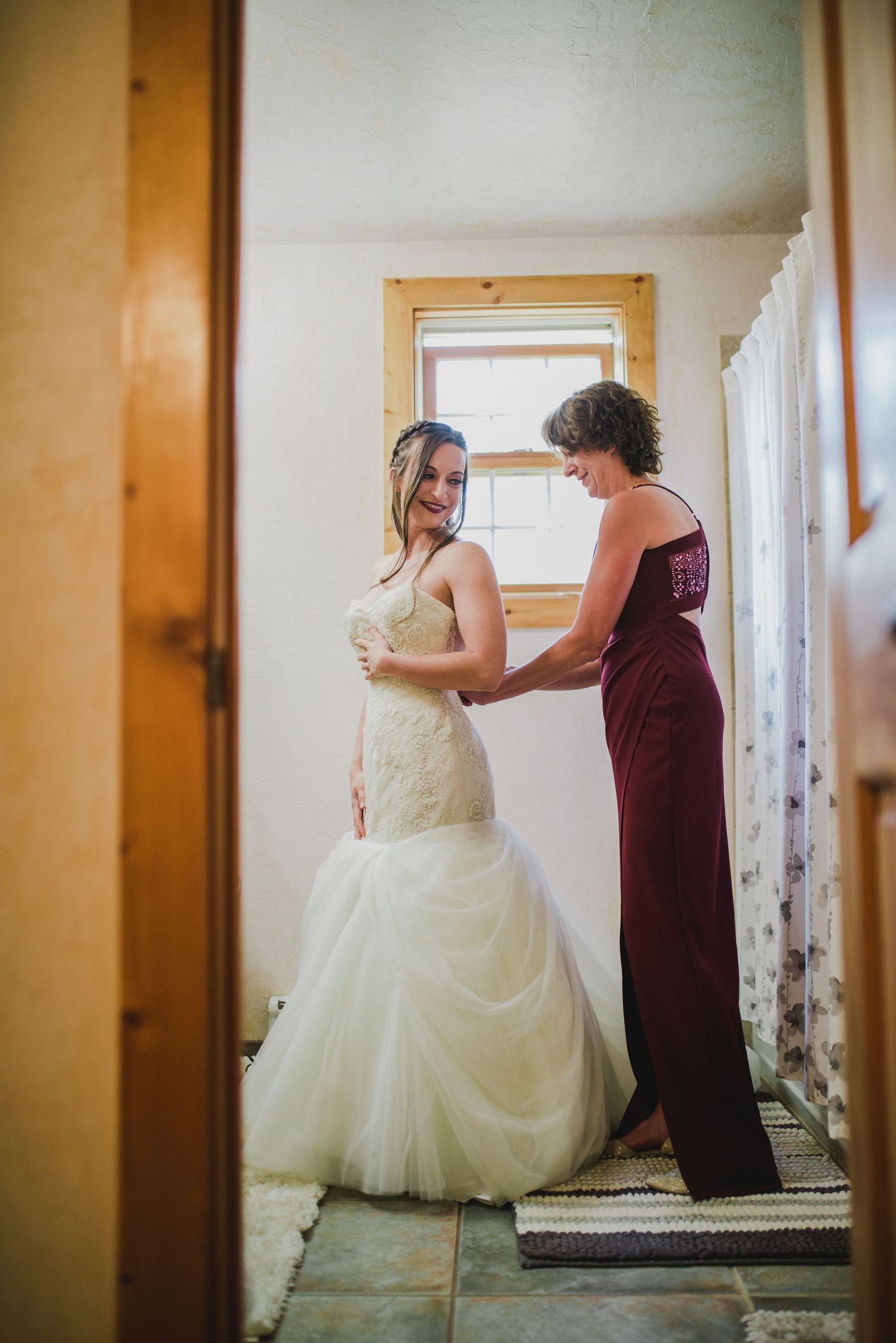 Intimate moment between two people in a hallway, one wearing a white wedding gown.