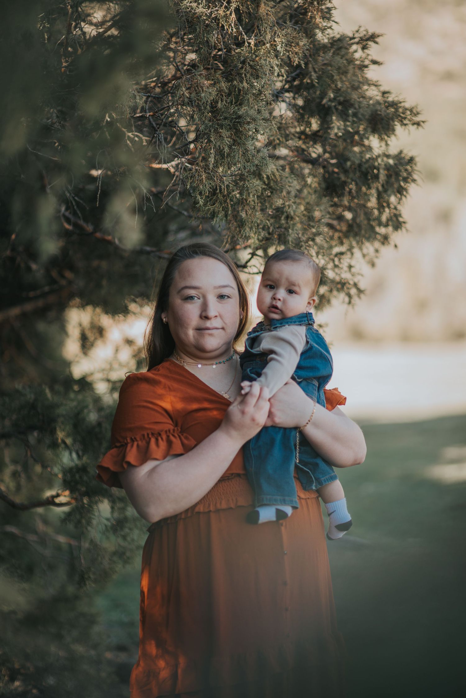 Mother and 1-year-old baby under pine trees in northern New Mexico — tender family moment by Quiet Light by The Amoras.