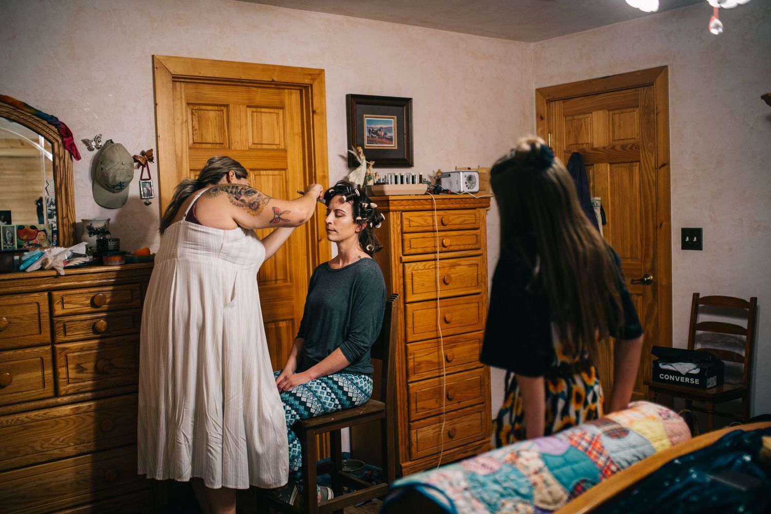 Wedding preparation scene in a bedroom with people getting ready for the special day.