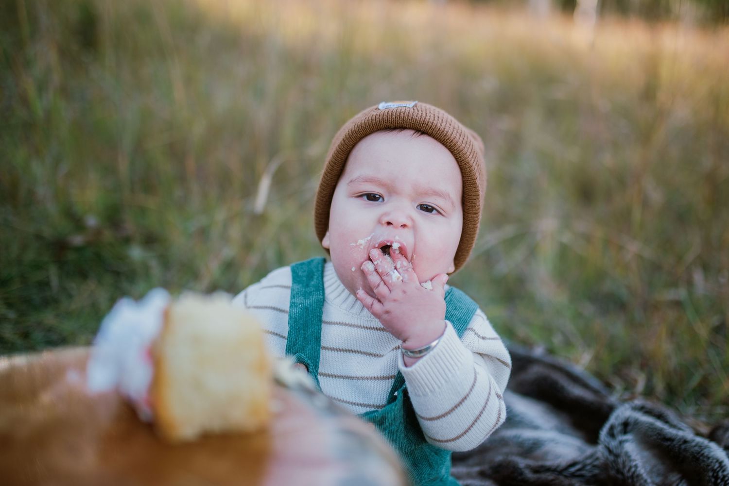Close-up outdoor portrait with green overalls against natural autumn backdrop.