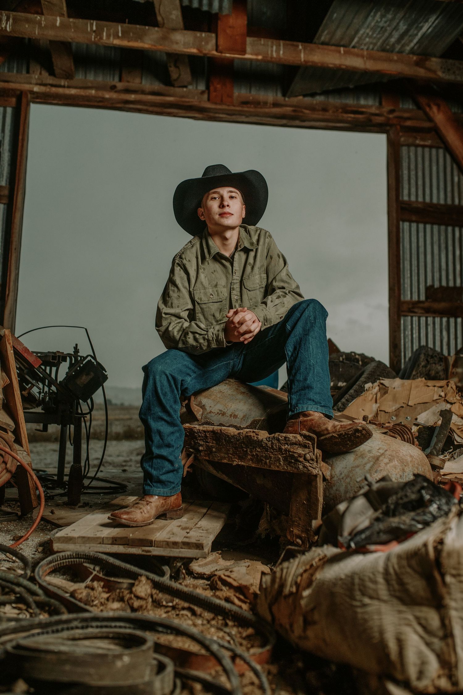 Vintage-inspired cowboy scene with denim, boots and rustic textures in moody lighting.
