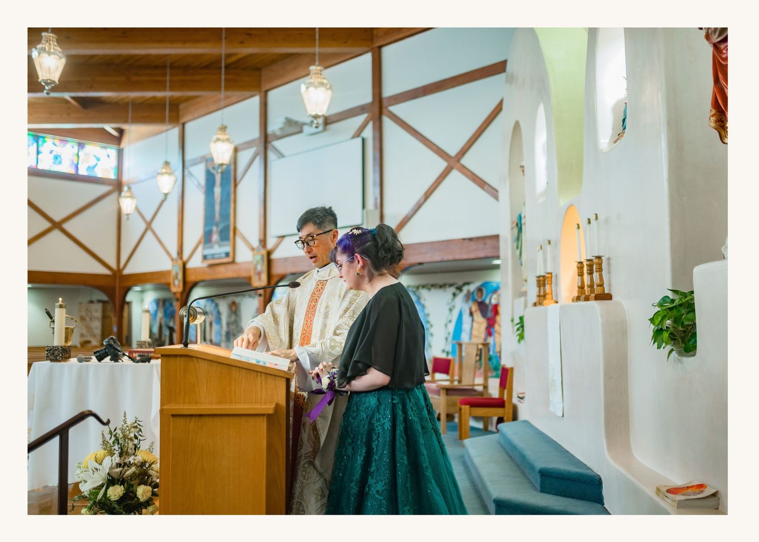 Couple standing at church altar during wedding ceremony in a colorful chapel setting.