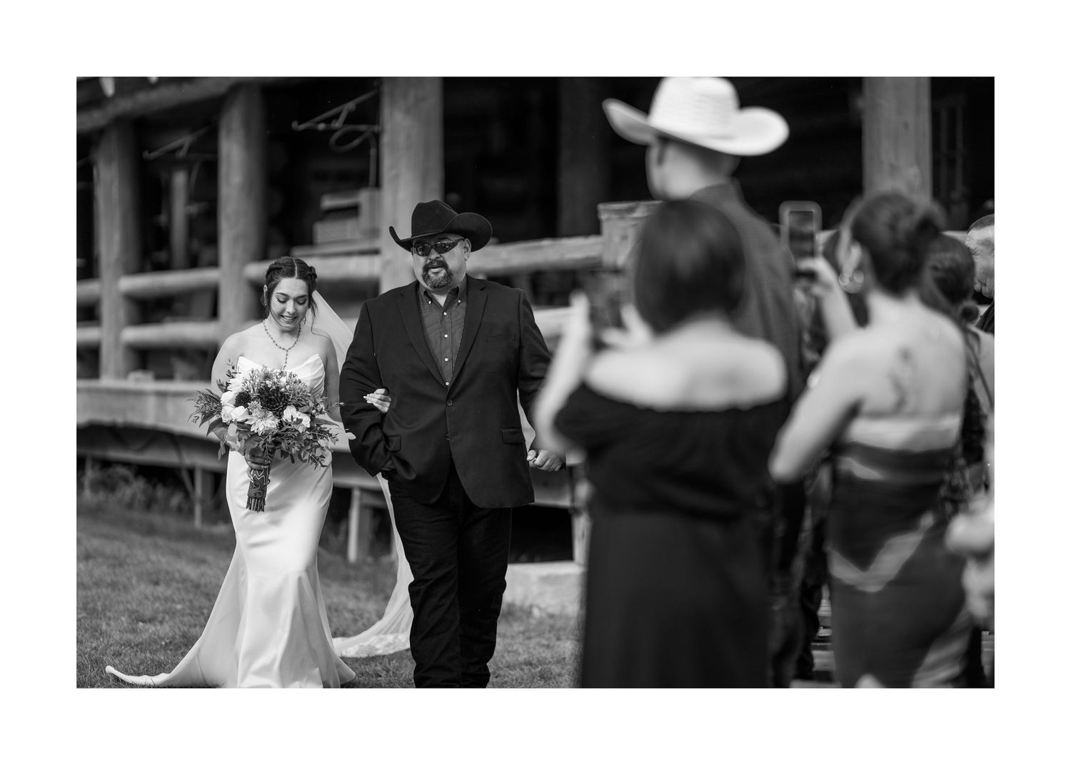Wedding guests celebrate on a patio during an outdoor evening reception with lights strung overhead.