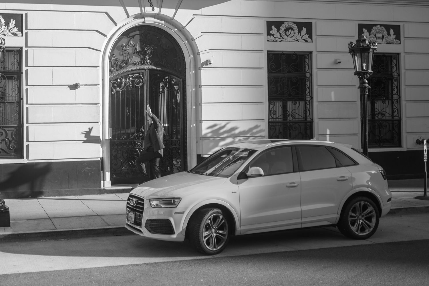 Silver Mercedes-Benz car parked on a street next to a white building.