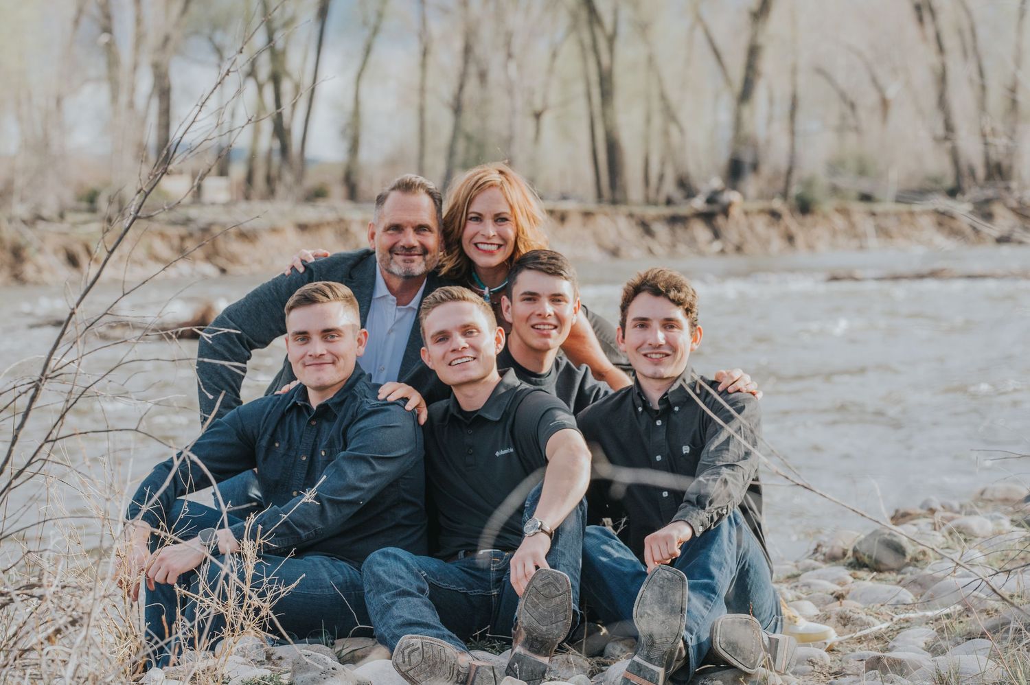 Candid shot of a family of six, all young adult sons, enjoying a lighthearted moment in the New Mexico high desert — by Quiet Light by The A