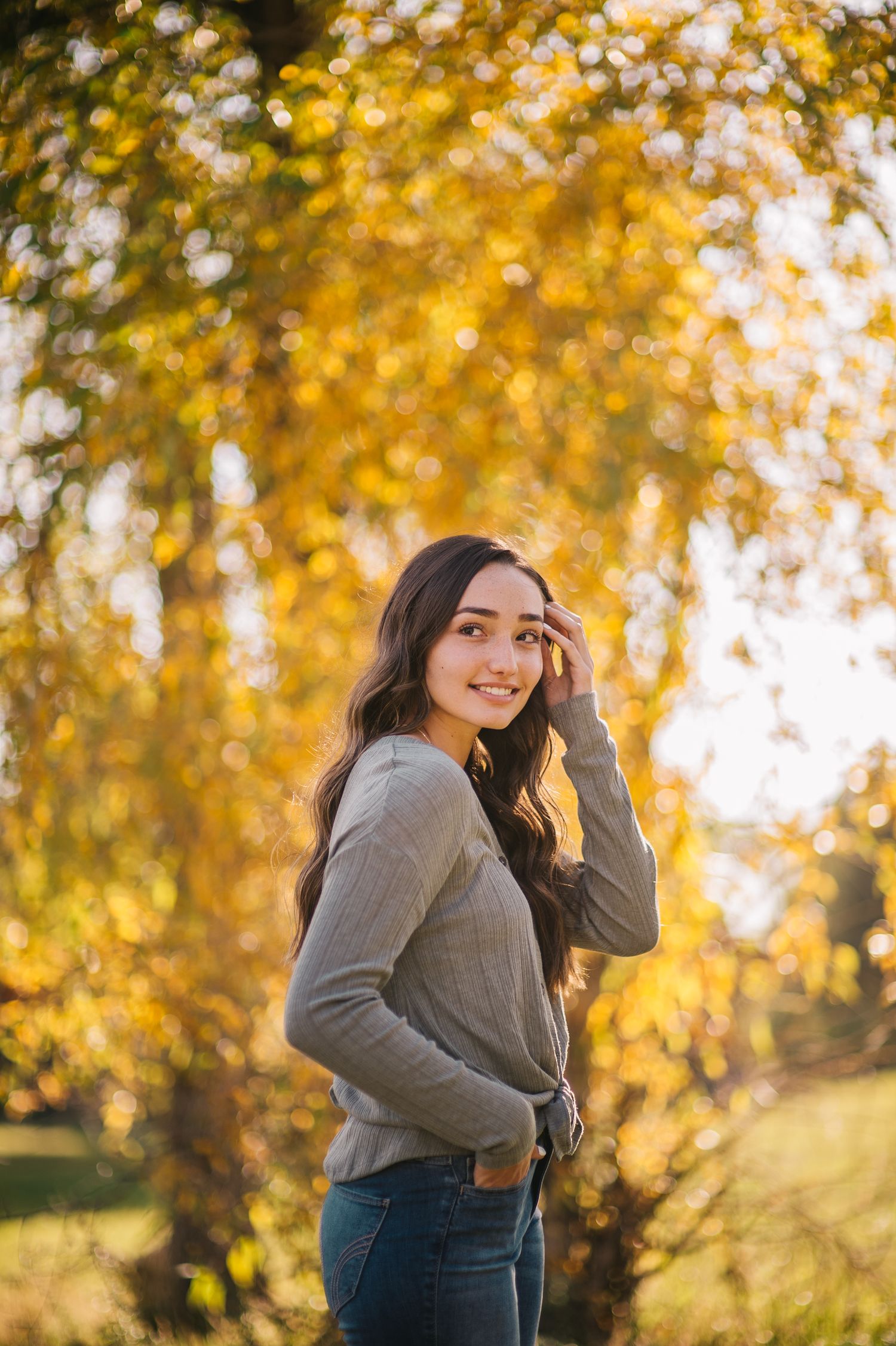 Casual outdoor portrait against vibrant yellow autumn trees.