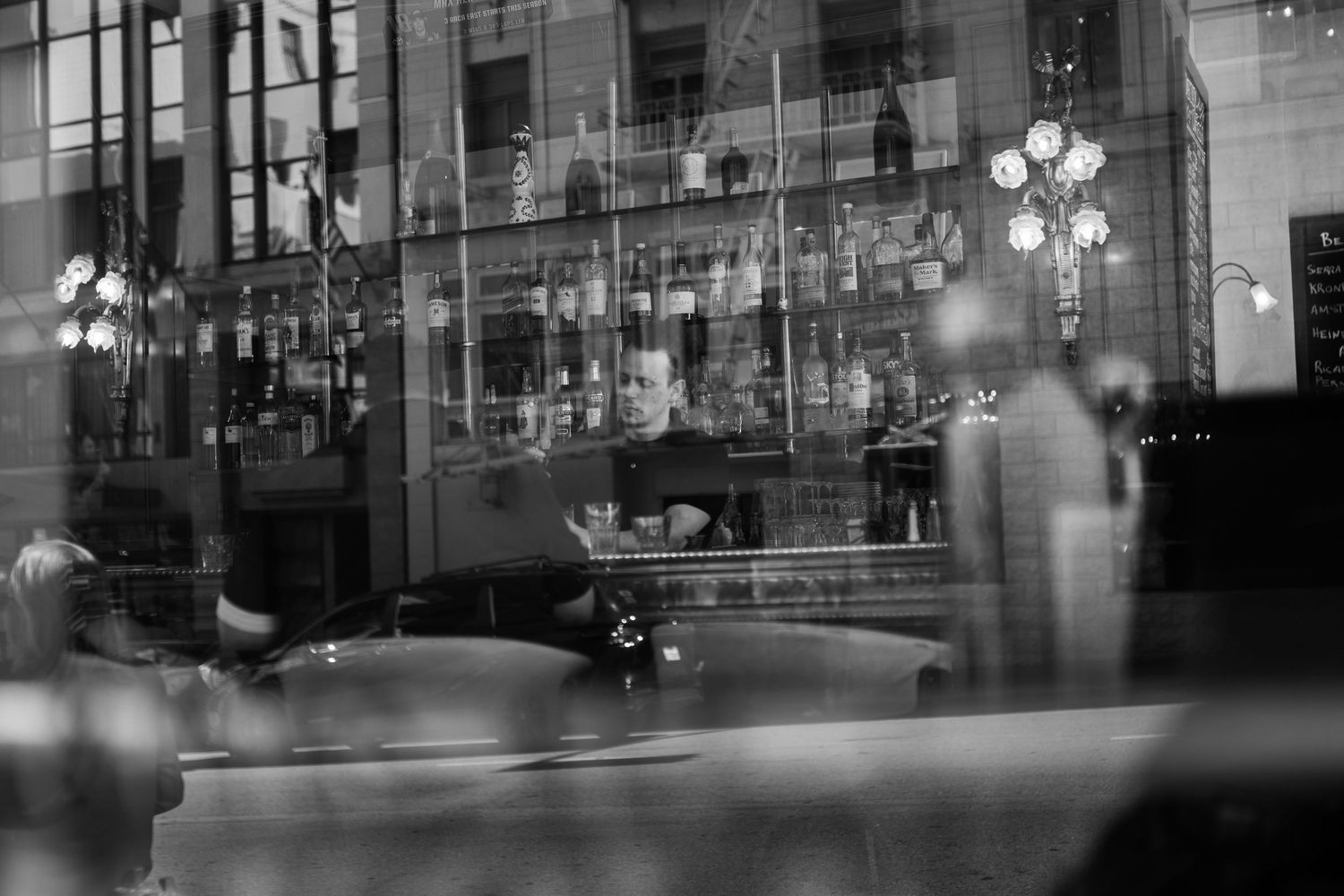 A row of illuminated street lamps adds a warm glow to a darkened city street at night.