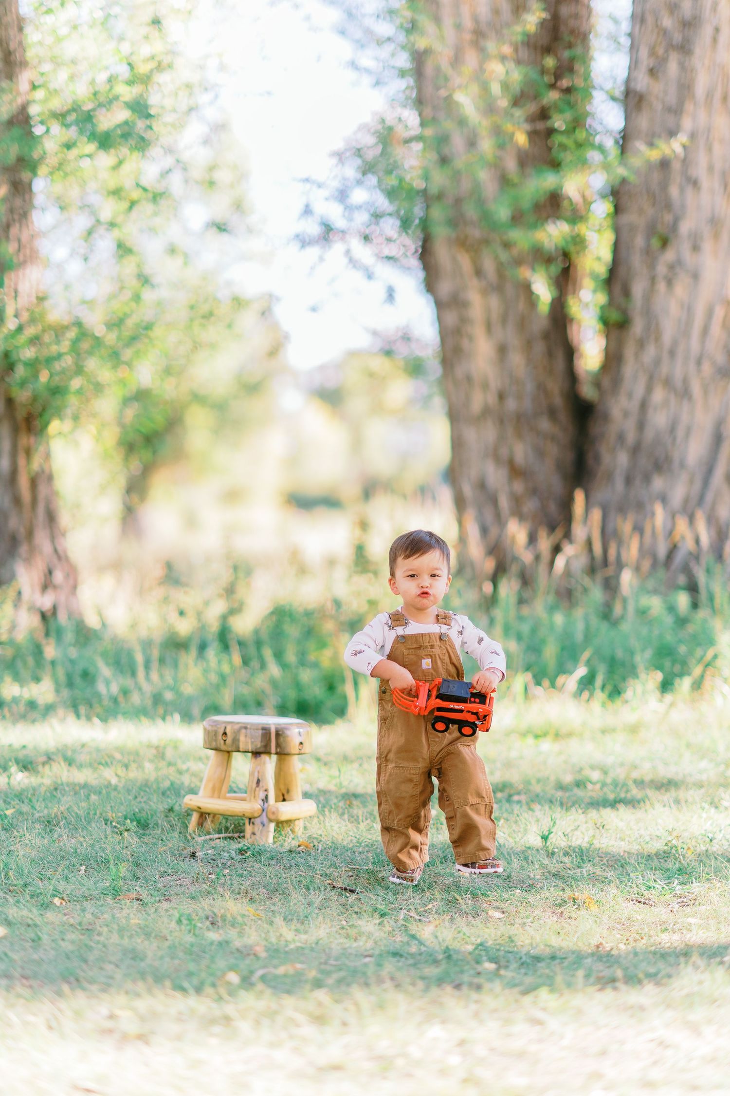 A series of outdoor photos showing a child in brown lederhosen playing in a sunny wooded area with rustic decor.