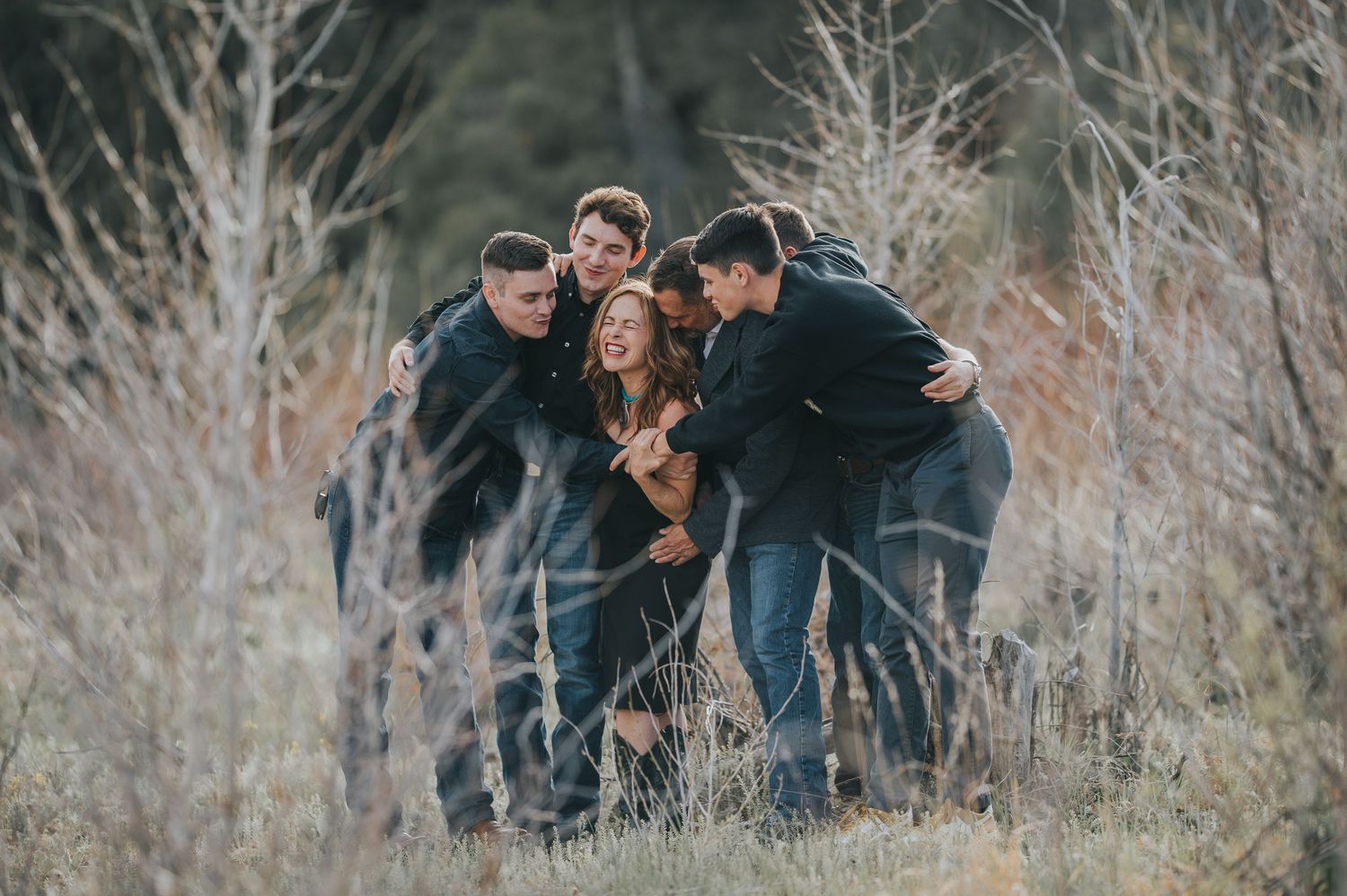 Family of six with young adult sons sharing a candid laugh in the golden light of northern New Mexico — captured by Quiet Light by The Amora