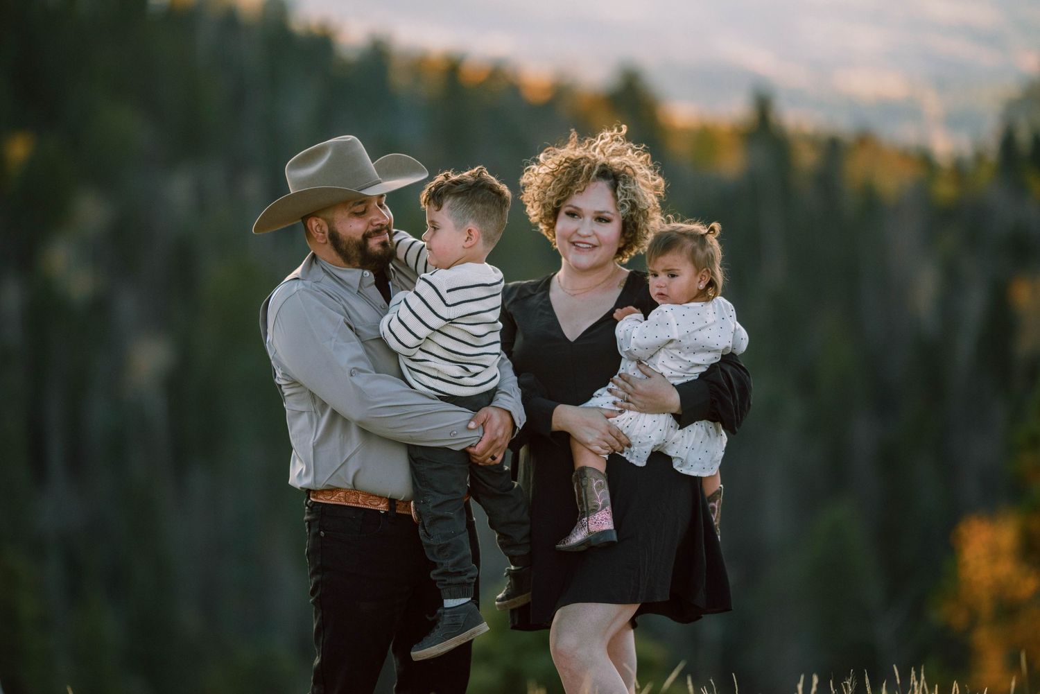 Family portrait session in forest during fall with mountain backdrop.