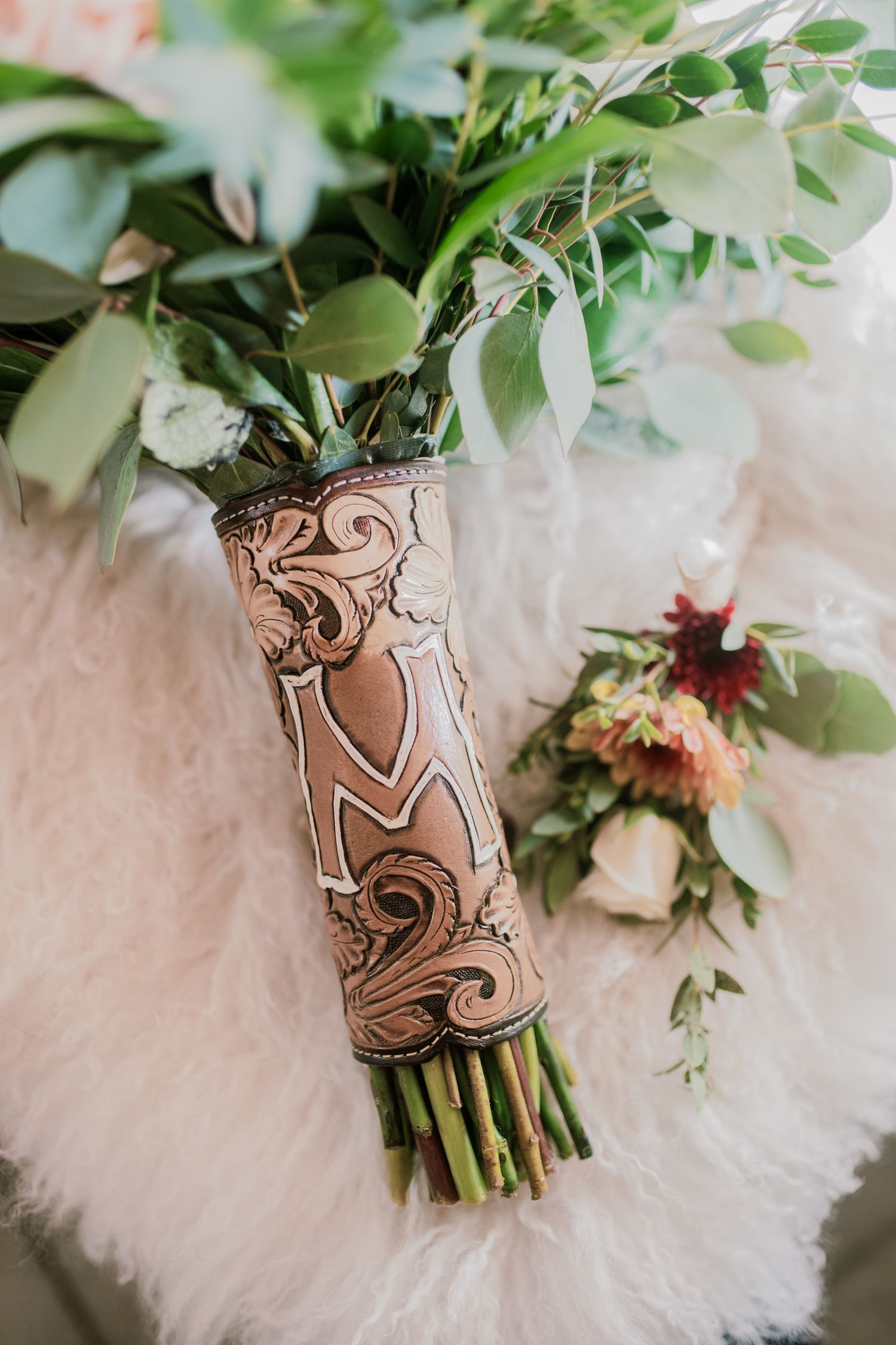 Wedding bouquet wrapped in leather, captured in soft light — floral detail photo by The Amoras in Chama, NM.
