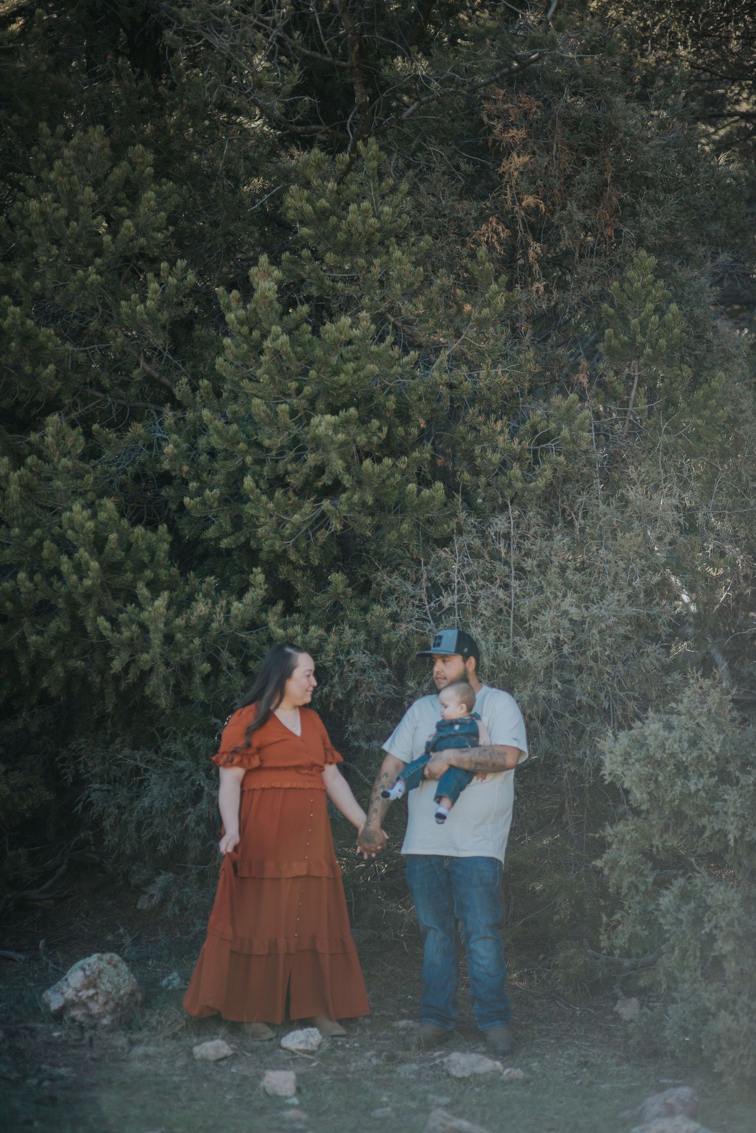 Parents and toddler son exploring the high desert shrubland of northern New Mexico — candid family moment by The Amoras.