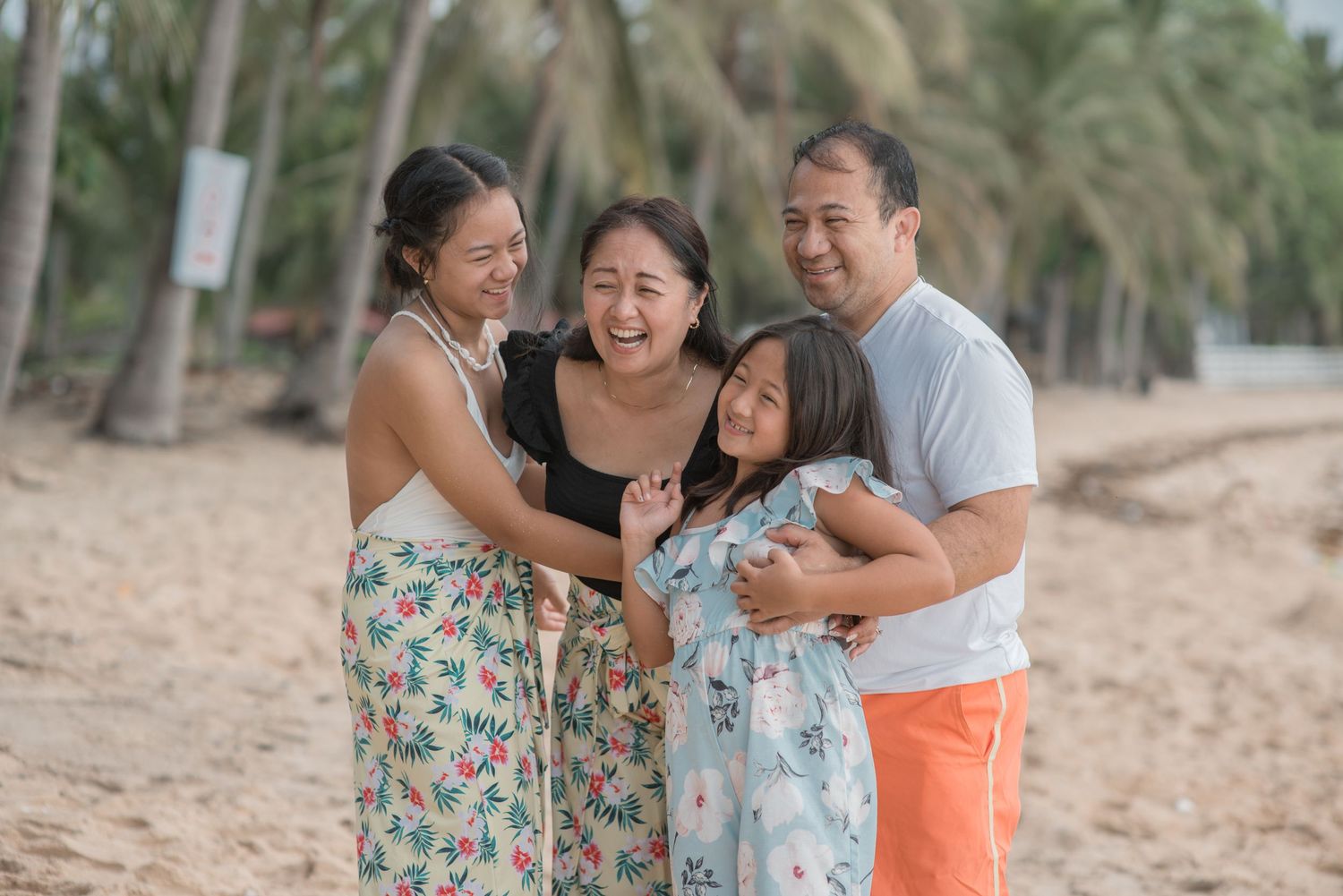 Family enjoying a beach day together among palm trees.