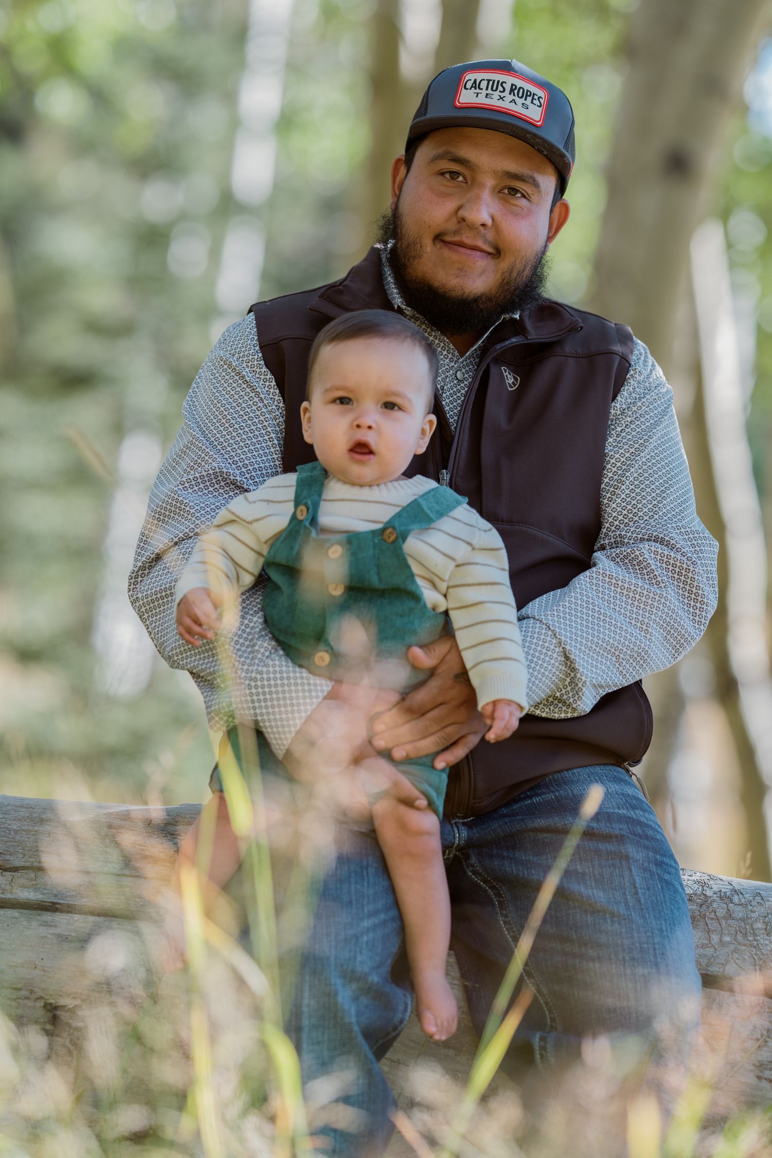 Father and baby enjoying outdoor time together in wooded area.
