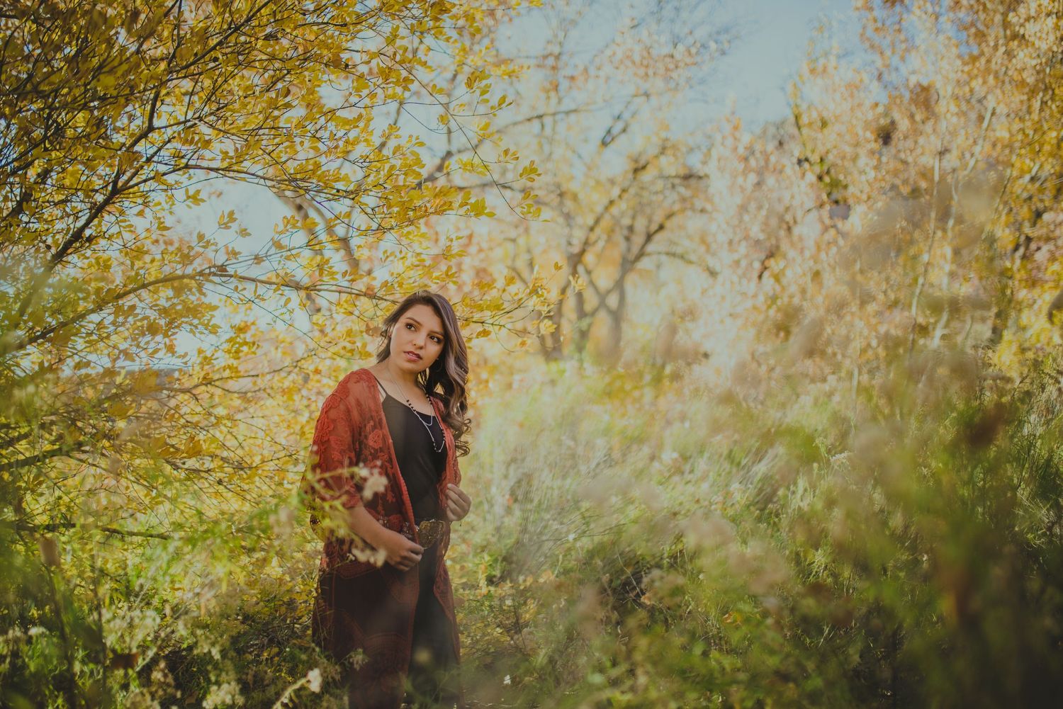 Beautiful outdoor photoshoot with golden autumn trees and natural lighting.