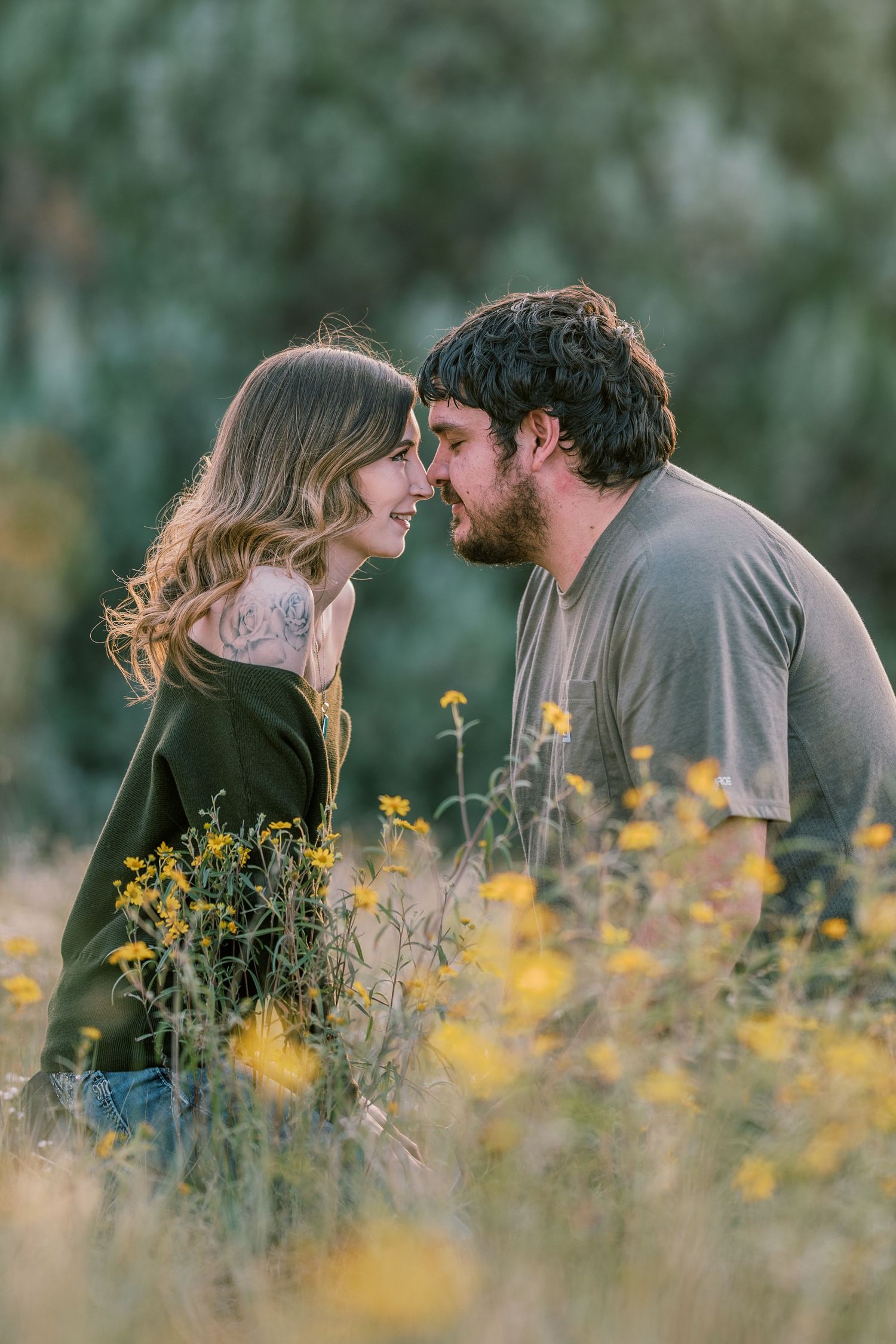 Romantic couple sharing intimate moments among blooming yellow wildflowers.