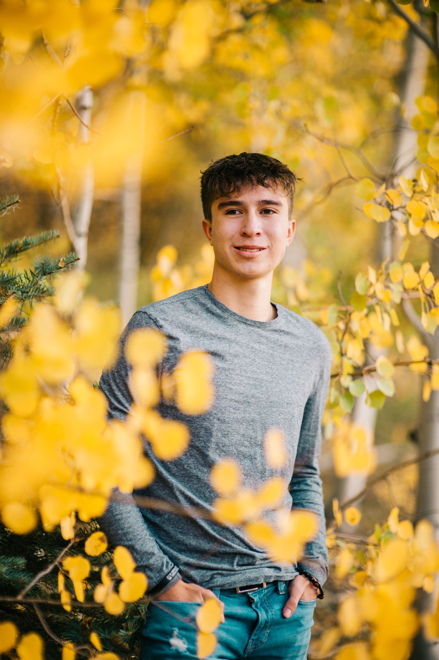 Portrait against golden autumn aspen trees with natural lighting.