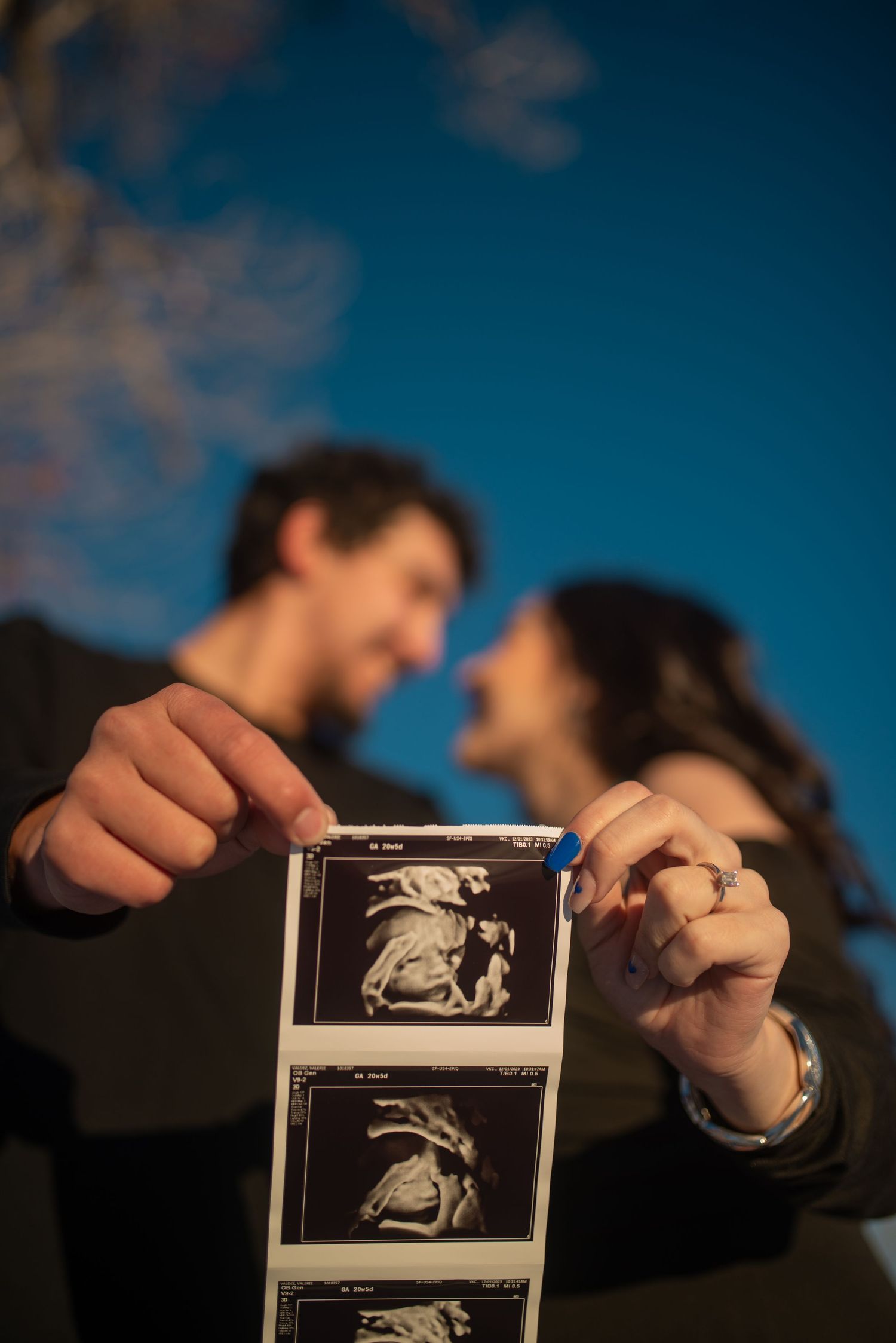 Candid maternity portrait of a couple smiling while holding an ultrasound photo — soft, heartfelt storytelling by Quiet Light by The Amoras