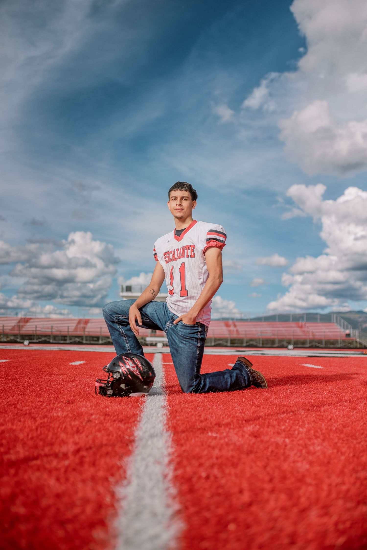 A sequence of photos showing someone sitting on a red sports field track against a blue cloudy sky.