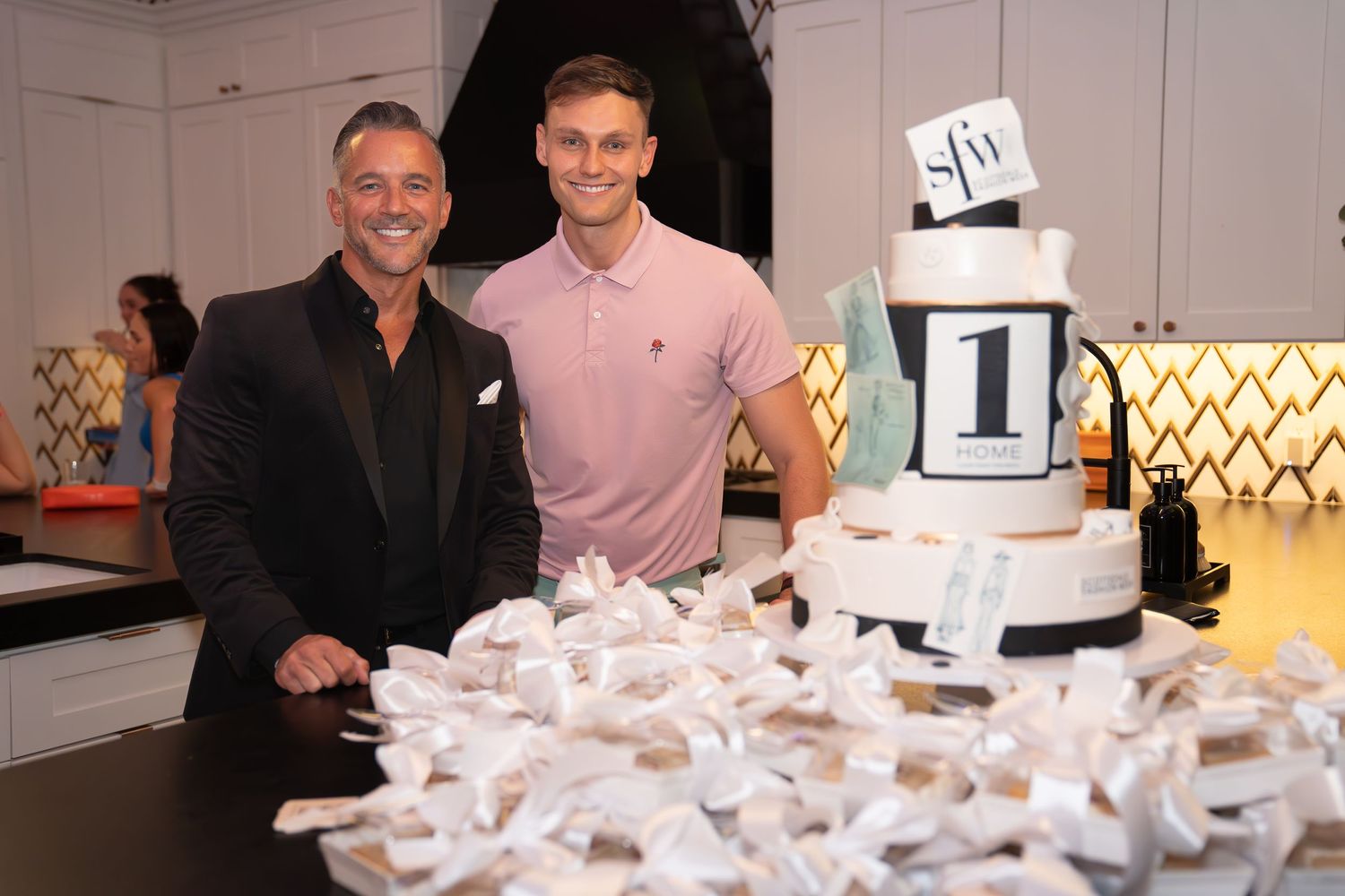 man with a suit, man with a pink t-shirt, giant black and white cake, the 1 home