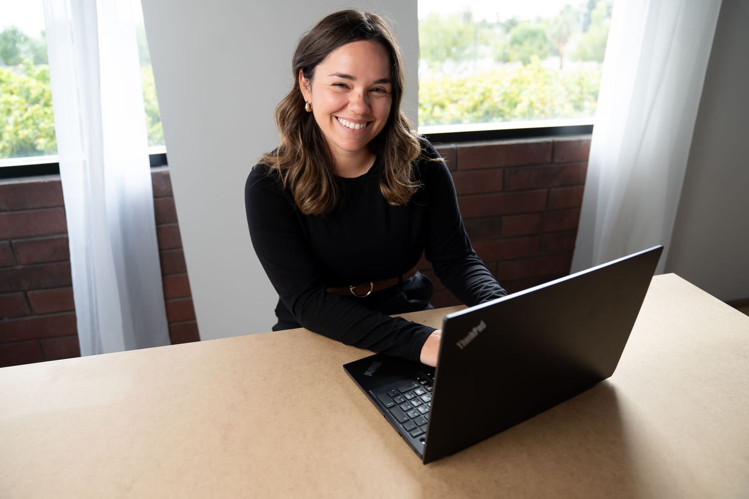 girl wearing black long sleeves, typing on computer