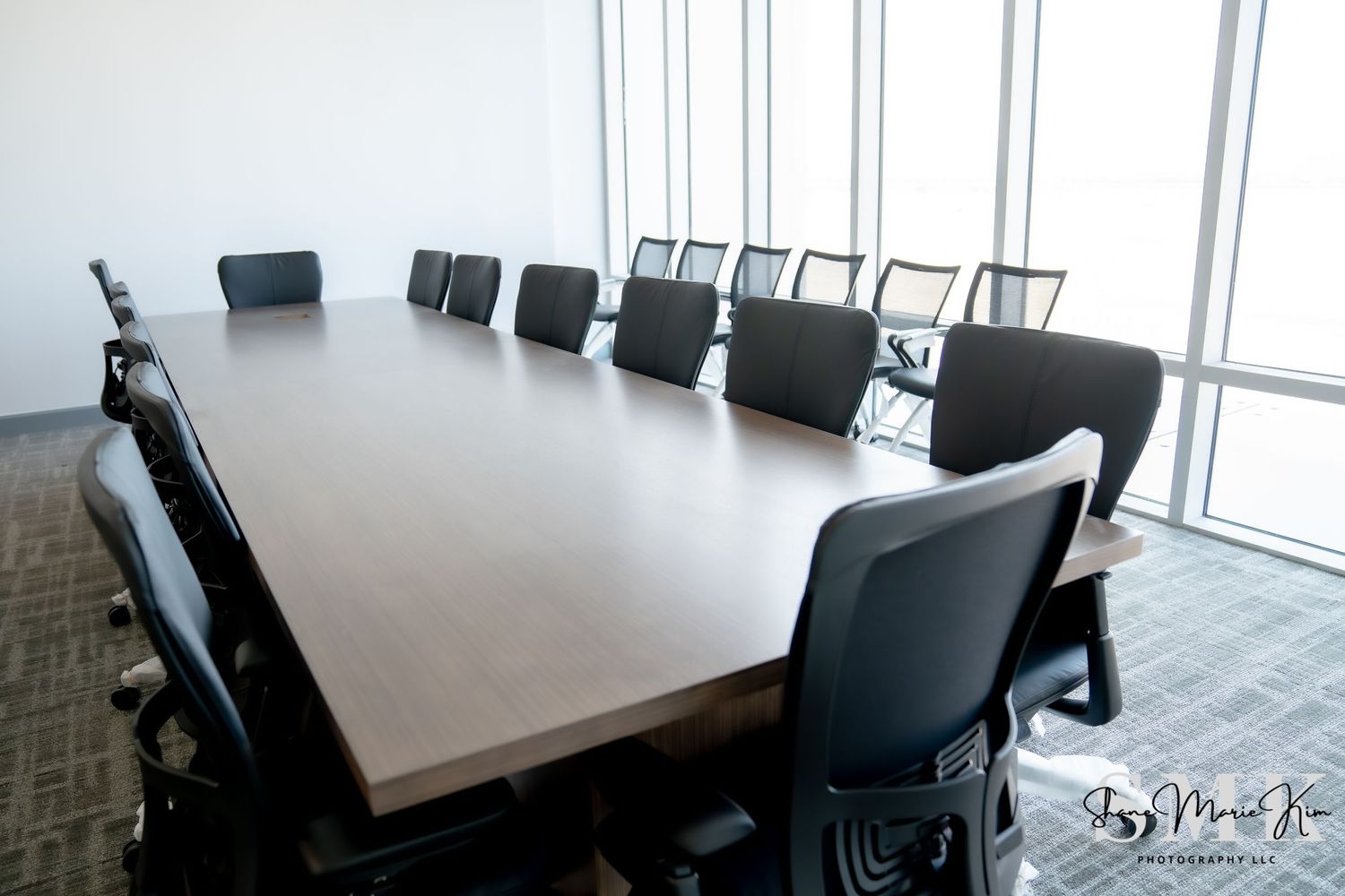 large conference room with long conference table with tall windows that overlook the airport