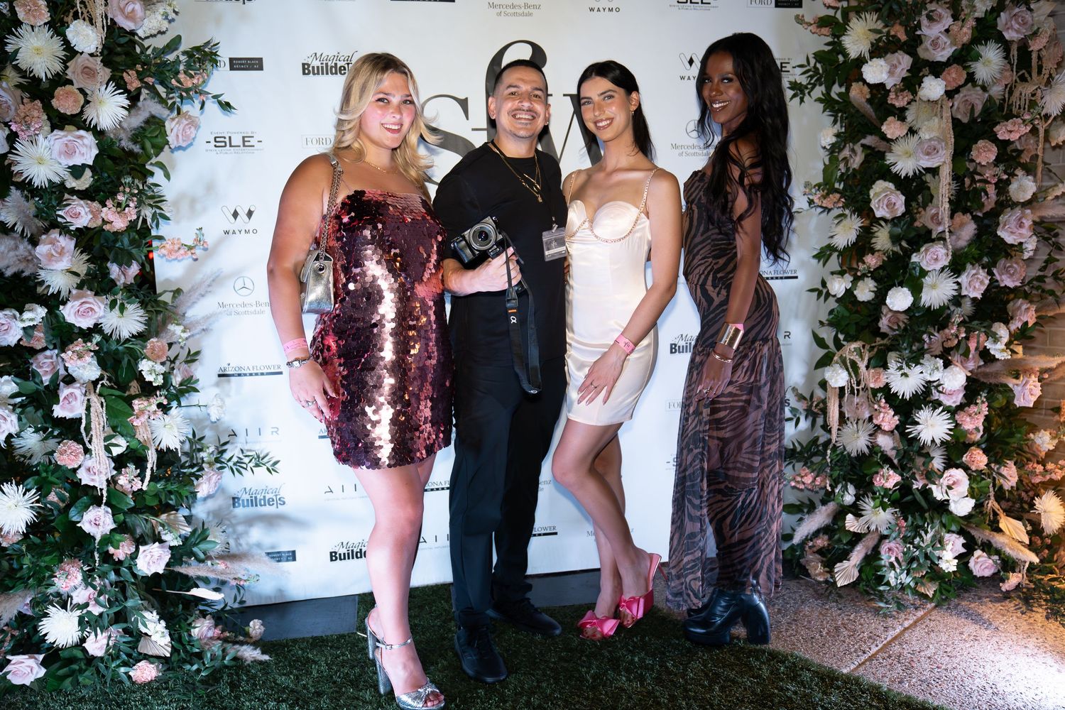 girl wearing a pink sparkly dress, man holding a camera, girl wearing a short white, sleeveless dress, girl wearing long printed black dress