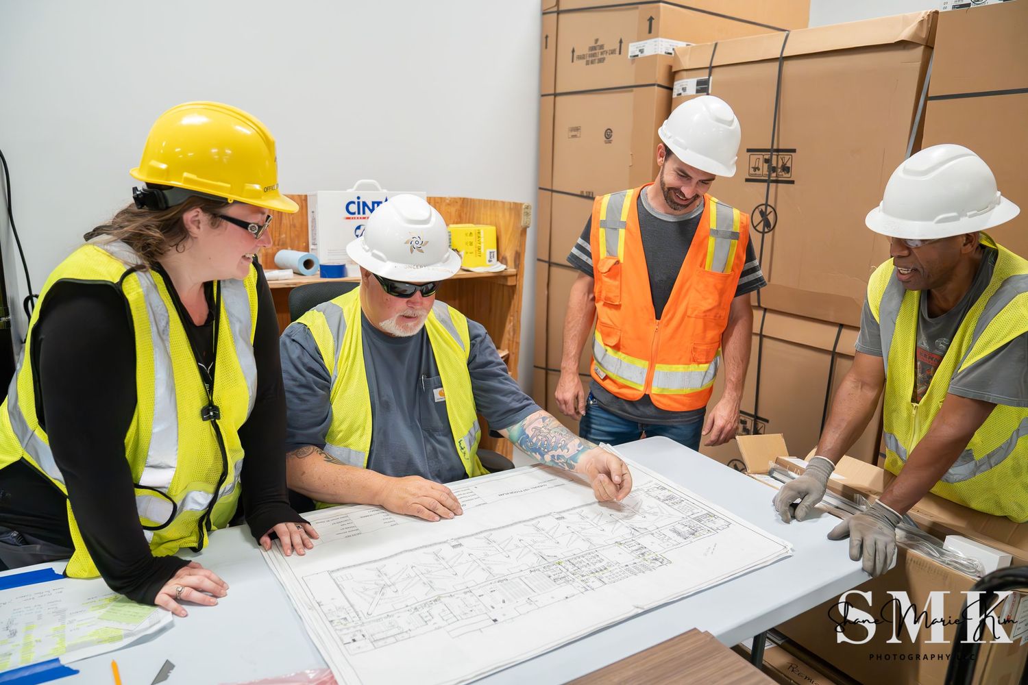construction workers looking at a blue print and smiling and engaging