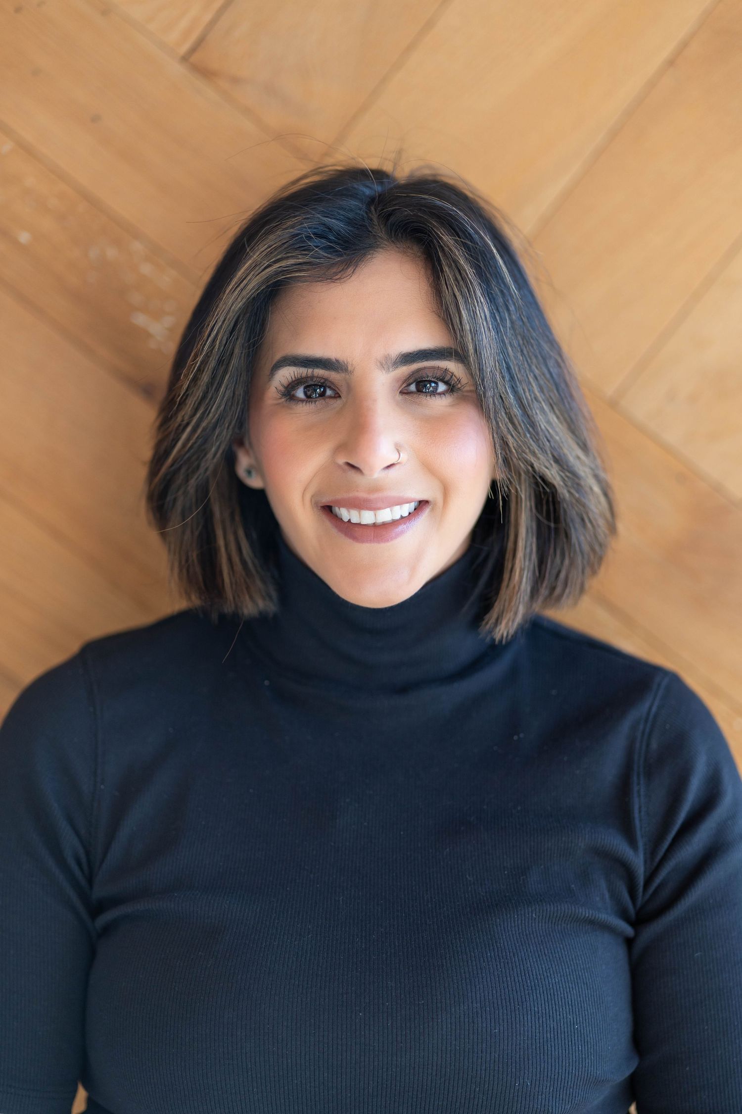 woman with short brown, balayage hair, woman wearing black