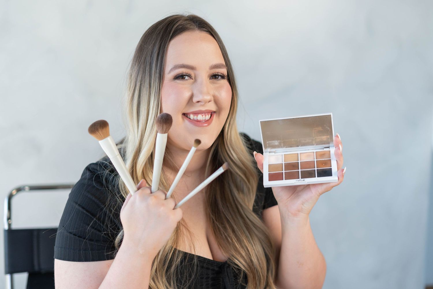 girl holding make up brushes and make up palette