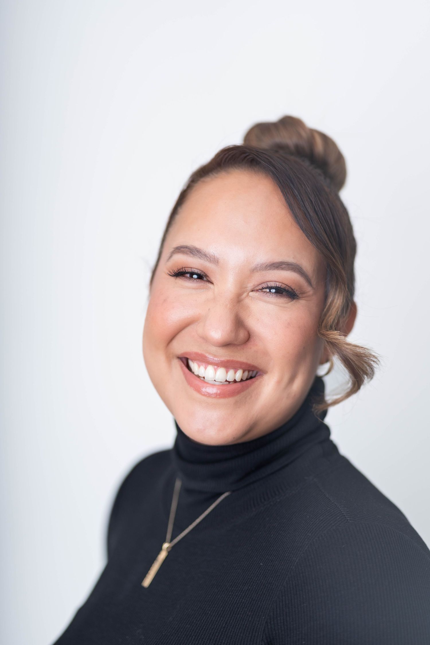 women with hair bun, wearing a black turtle next