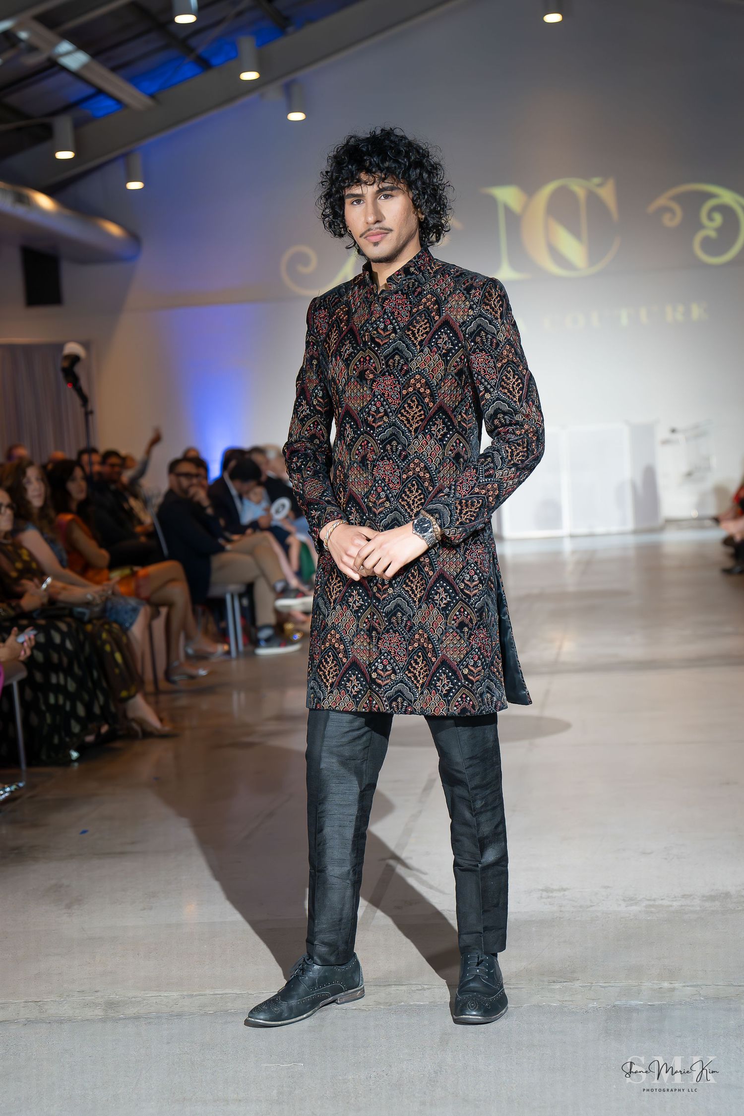 man with curly hair, wearing a patterned suit