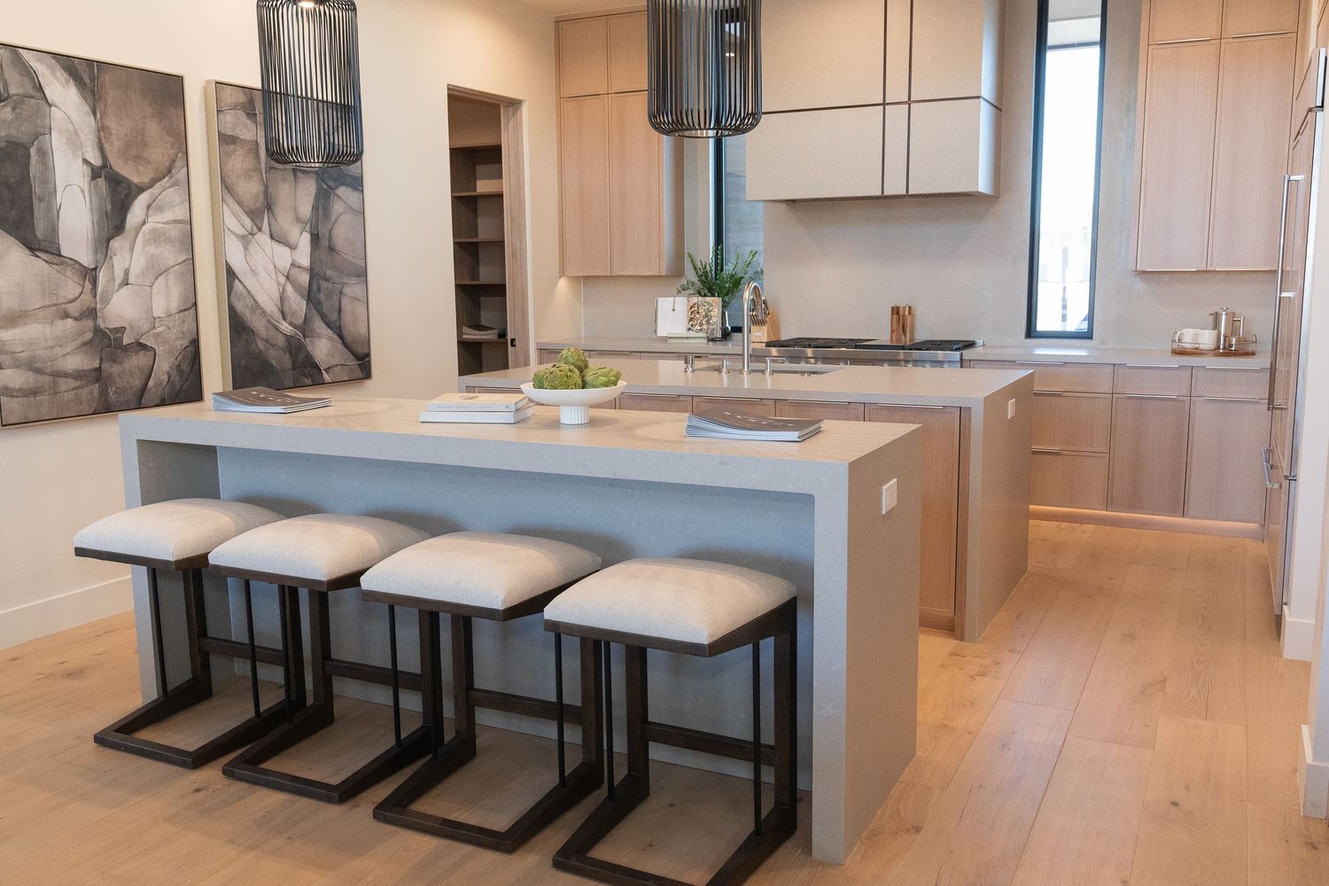 chef's kitchen with a double island, beautiful wall art and 4 bar stools