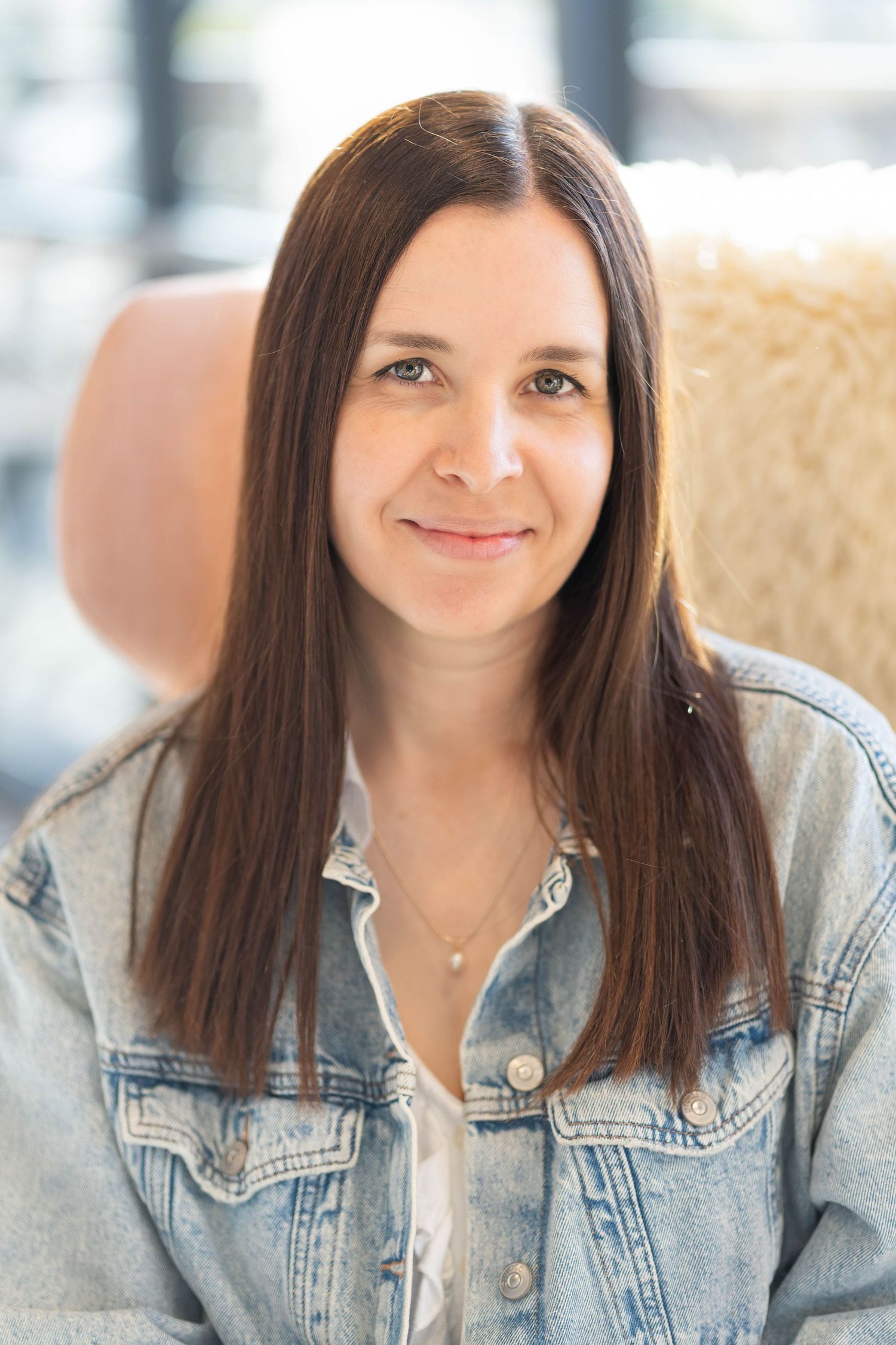 woman with brown hair, wearing a denim jacket