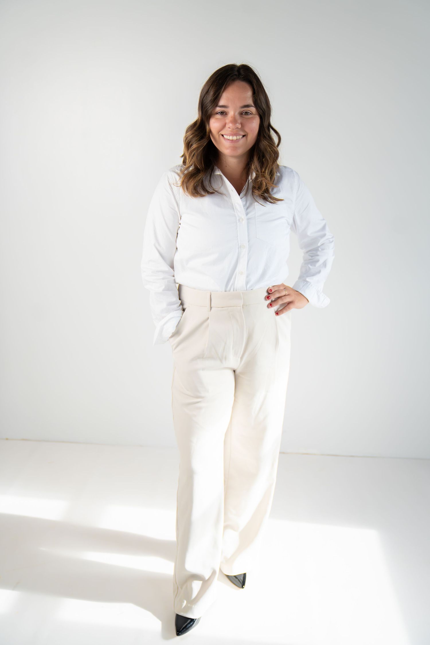 girl smiling and posing in a white studio