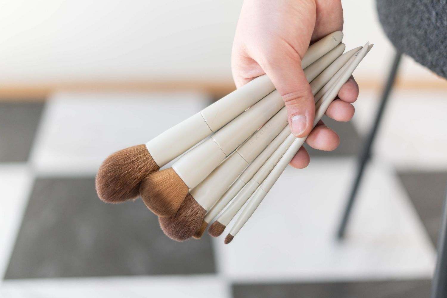 girl holding 6 make up brushes