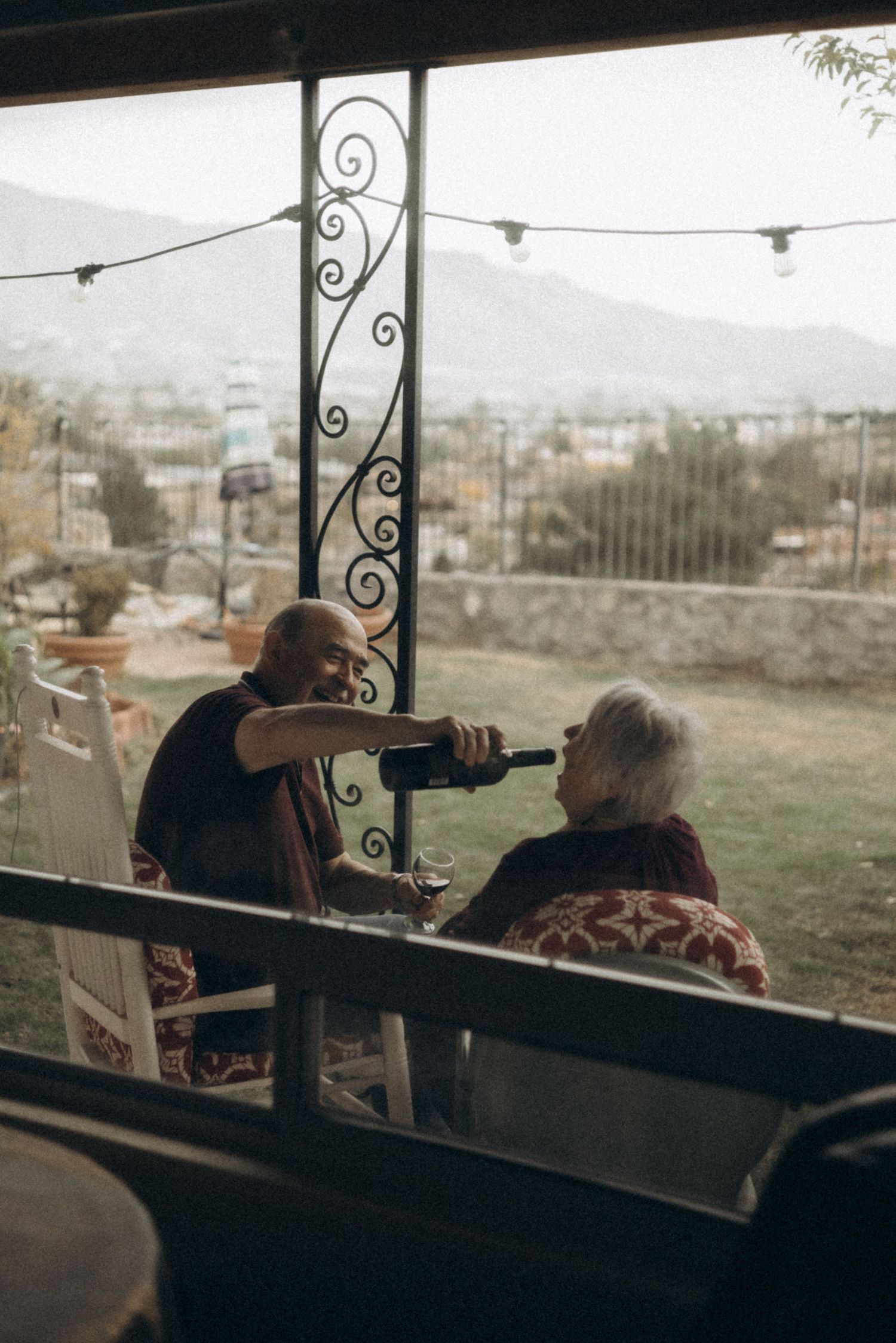 Group relaxing on a covered patio with mountain views in the background.