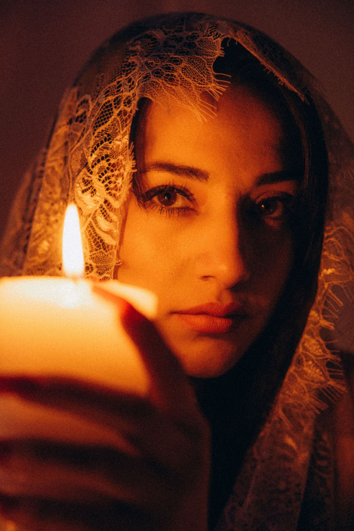 Candlelit portrait with dramatic orange glow and lace details.