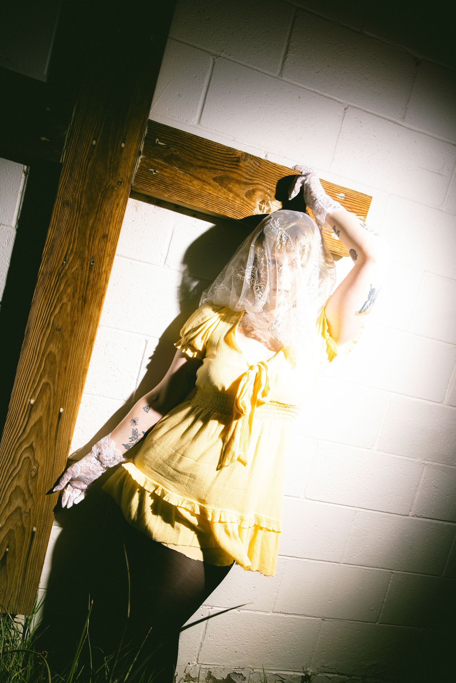 Artistic shots of a figure in a light colored dress against a dark wall with dramatic shadows.