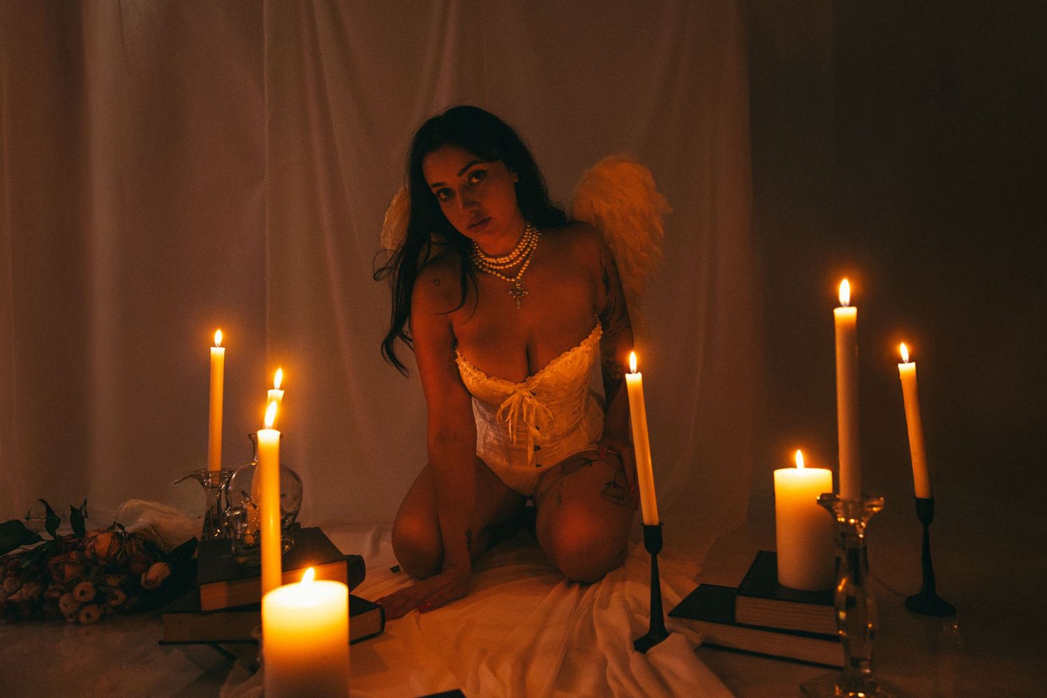 Moody boudoir photography with multiple candles creating warm ambient lighting.