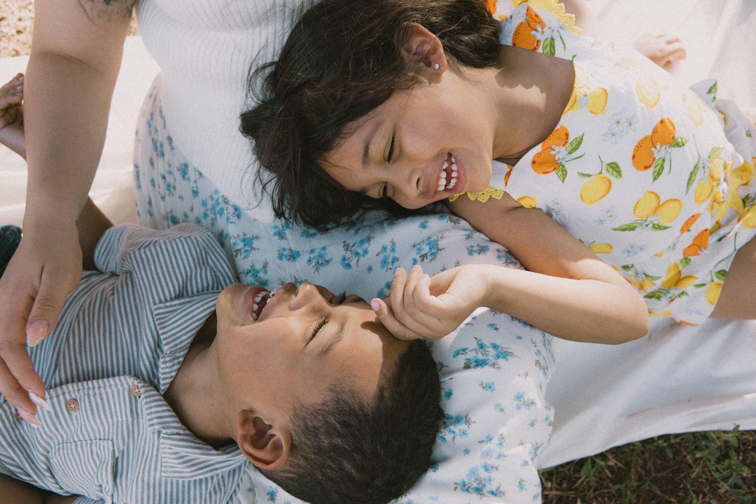 Romantic couple lying on floral bedding share intimate moments in a sequence of candid shots.